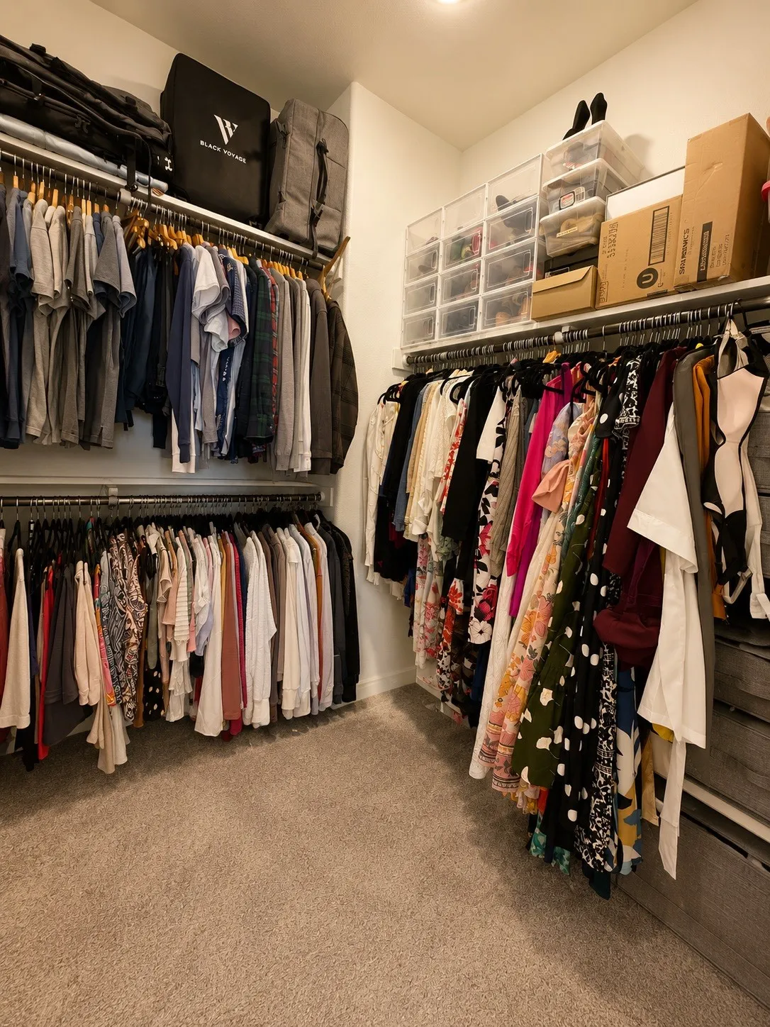 Built-in closet organization system with multiple hanging rods, integrated shelving, and neutral carpeting