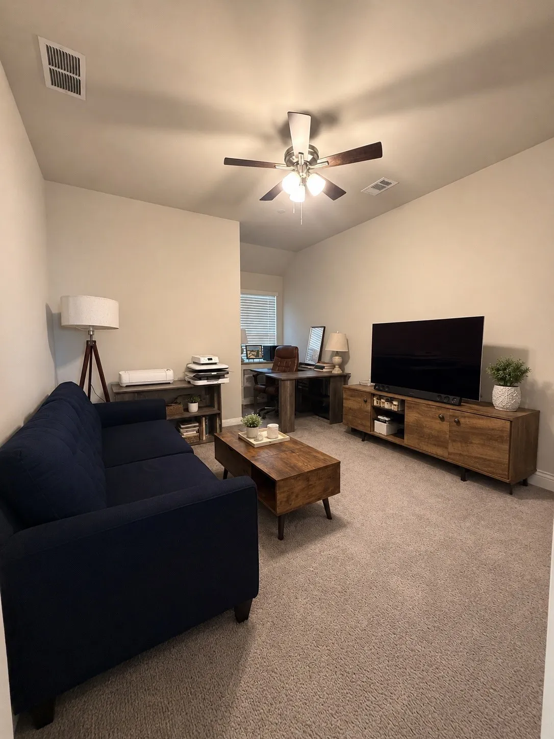 Carpeted living area with a ceiling fan light fixture