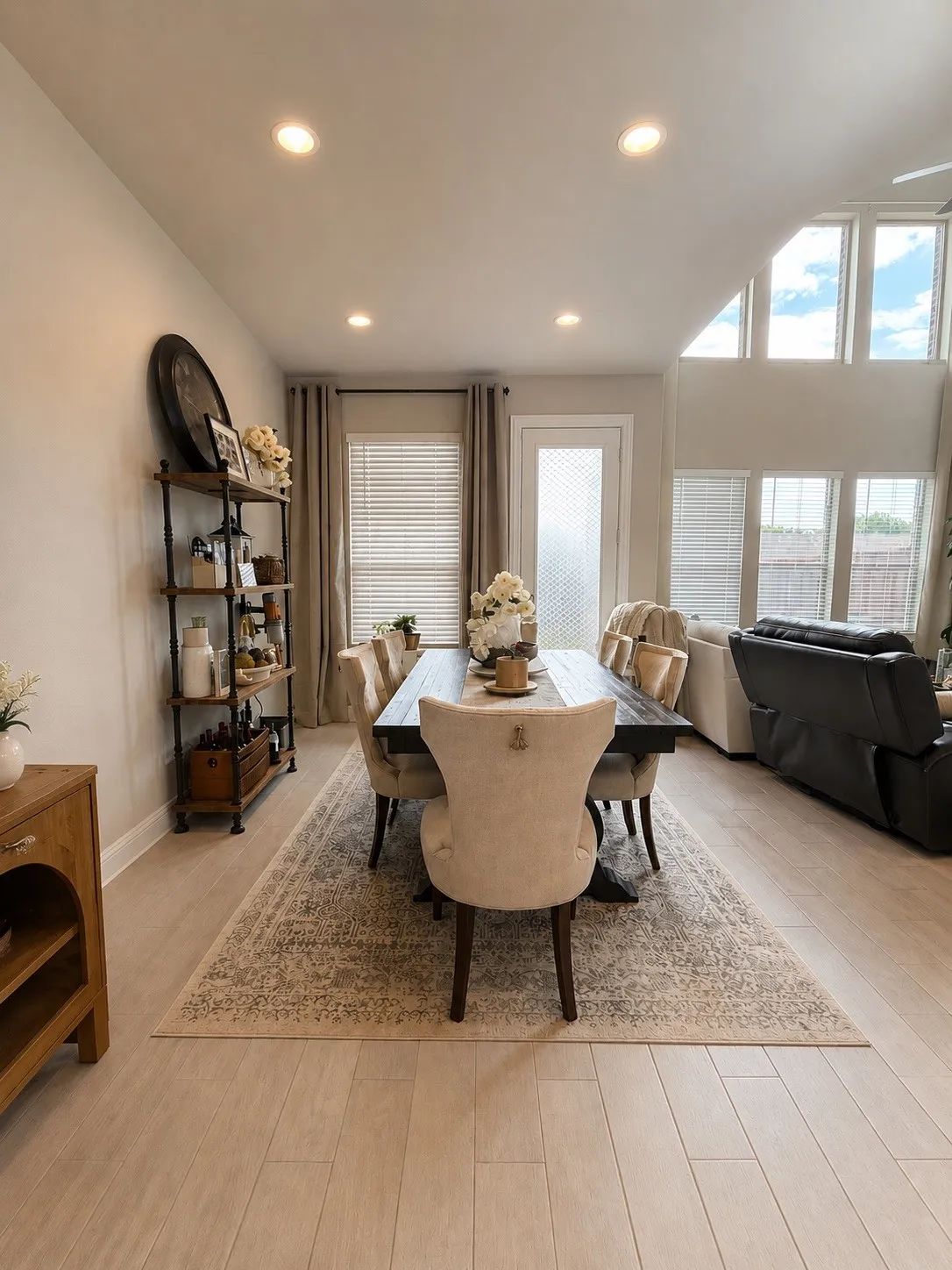 Vaulted ceiling with transom windows, recessed lighting, wood-finish flooring, and a glass-paneled exterior door