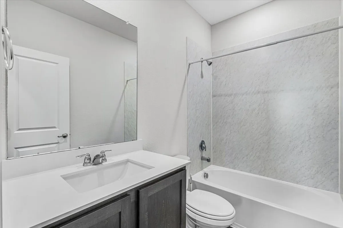 Vanity with an integrated rectangular sink, chrome faucet, and dark wood-finish cabinetry