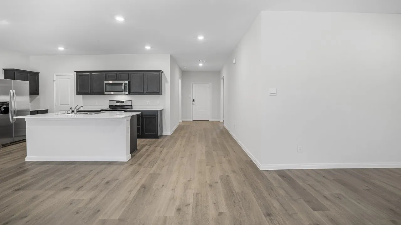 Open-concept living area featuring wood-finish flooring, recessed lighting, and a white kitchen island