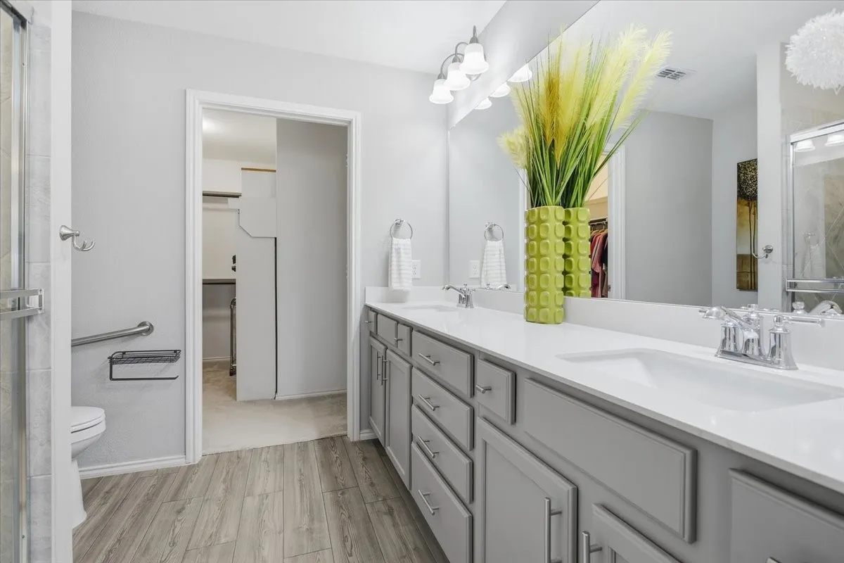 The primary bath has double sinks and plenty of storage. The door is currently taken off the closet but can be put back on when needed.
