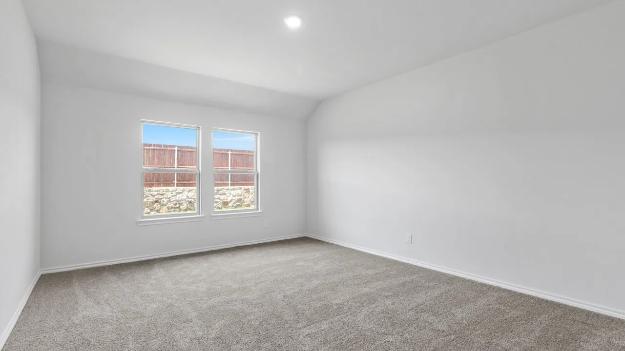Spacious room featuring neutral carpeting, white painted walls, two windows, and a recessed ceiling light