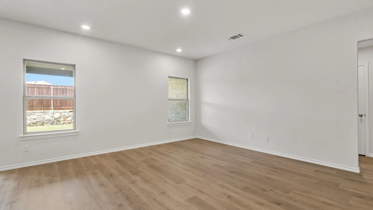 Expansive room featuring wood-finish flooring, recessed lighting, and bright white walls