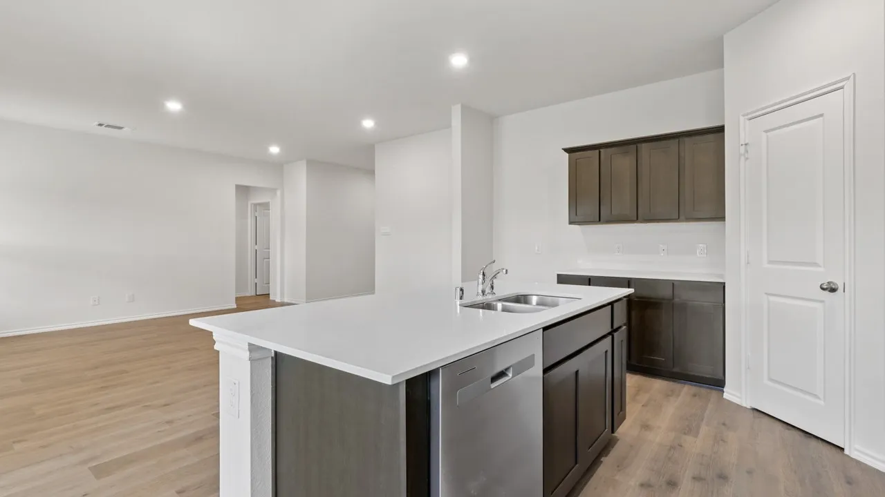Open concept kitchen featuring an island with a stainless steel double sink and dishwasher