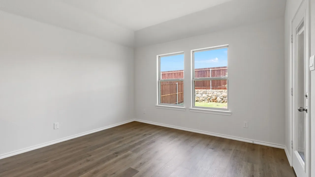 Room featuring wood-finish flooring, white baseboards, and bright white walls