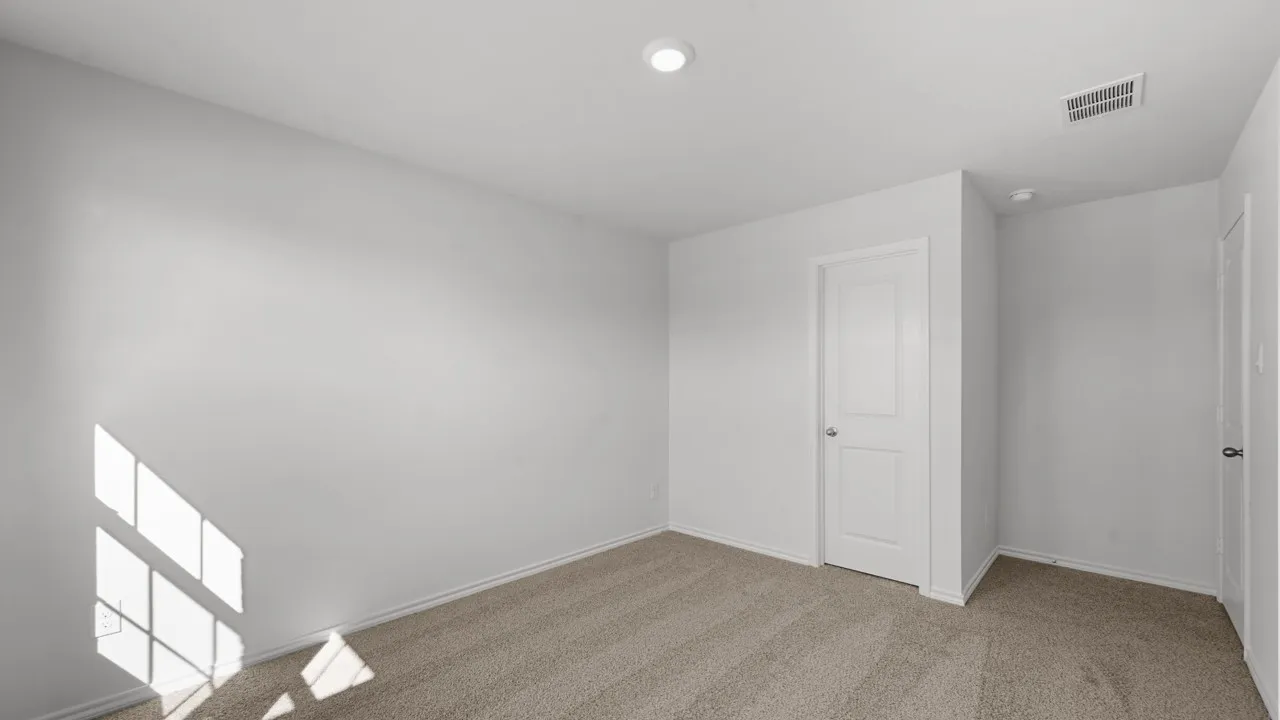Neutral-toned carpeting extends throughout this room, complemented by white walls and trim