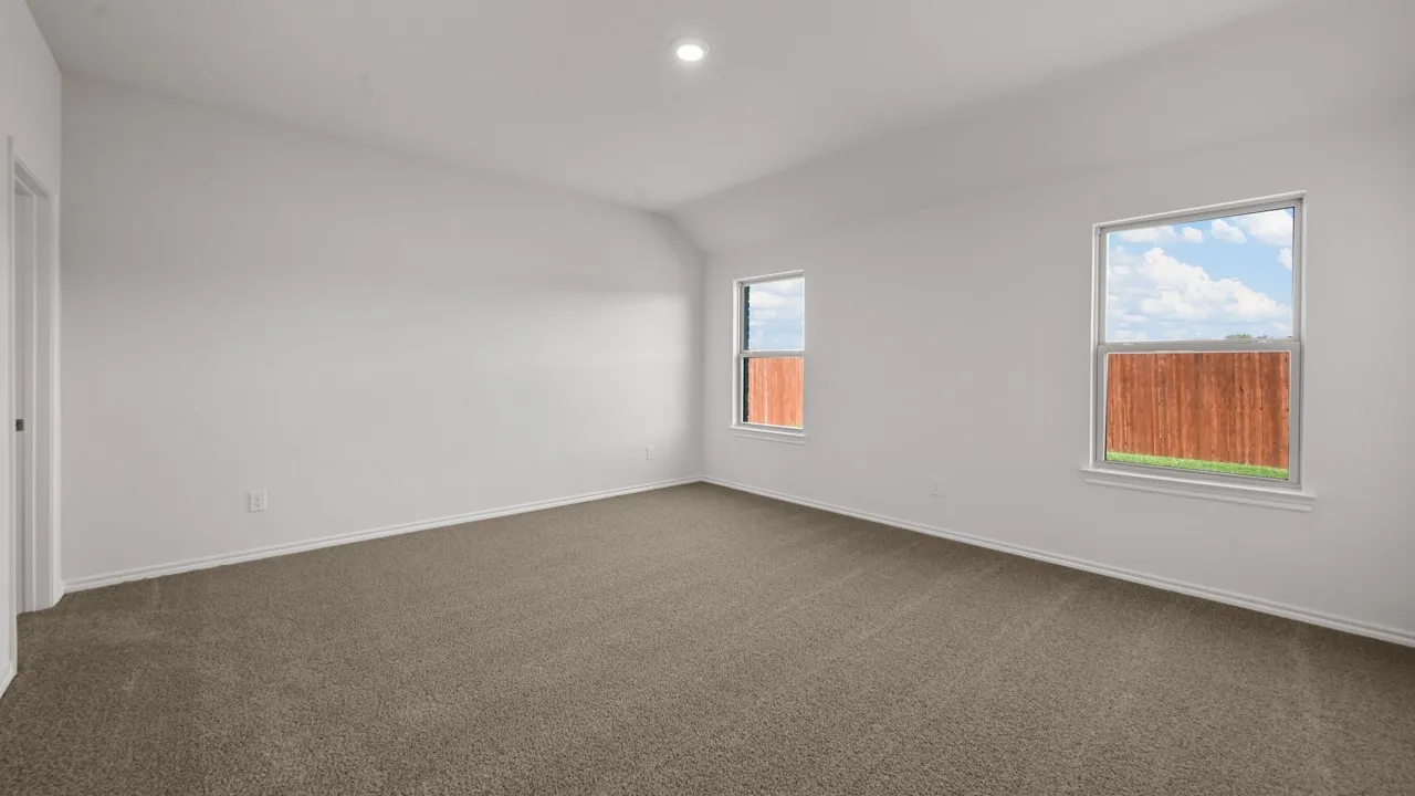 Spacious room featuring neutral carpeting and white baseboards