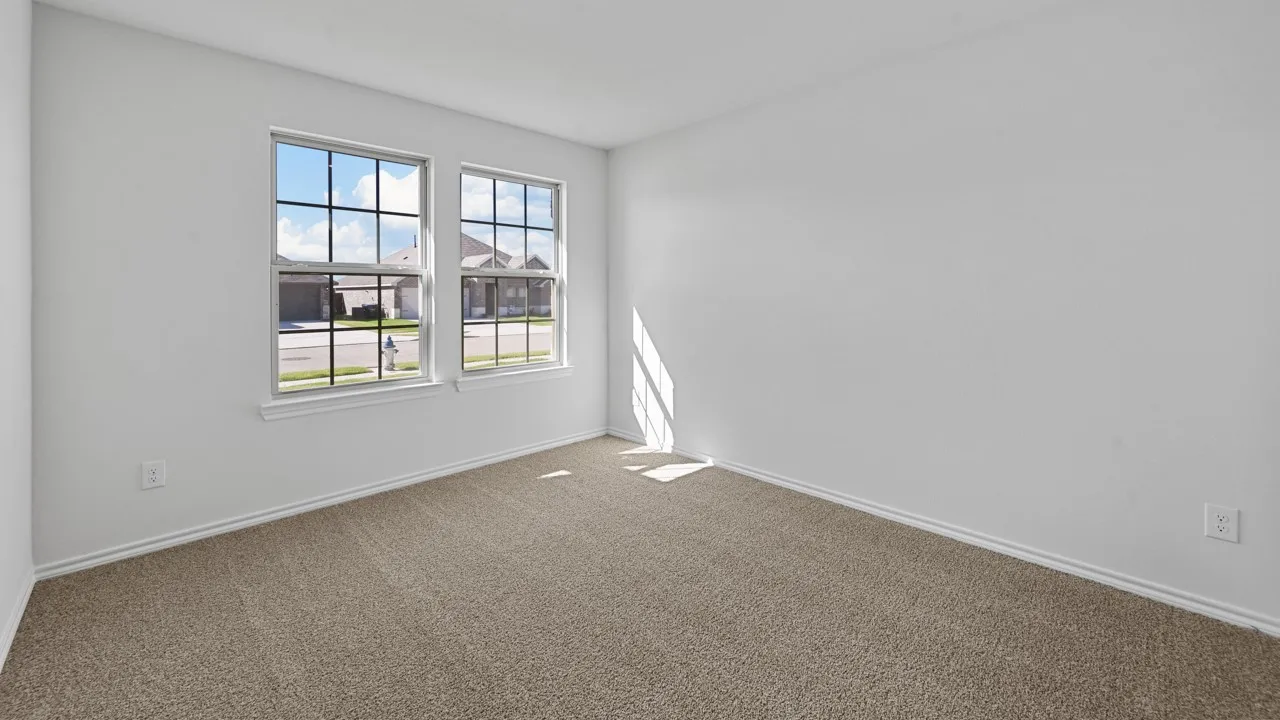 Room with neutral-toned carpeting, white walls, and white baseboards