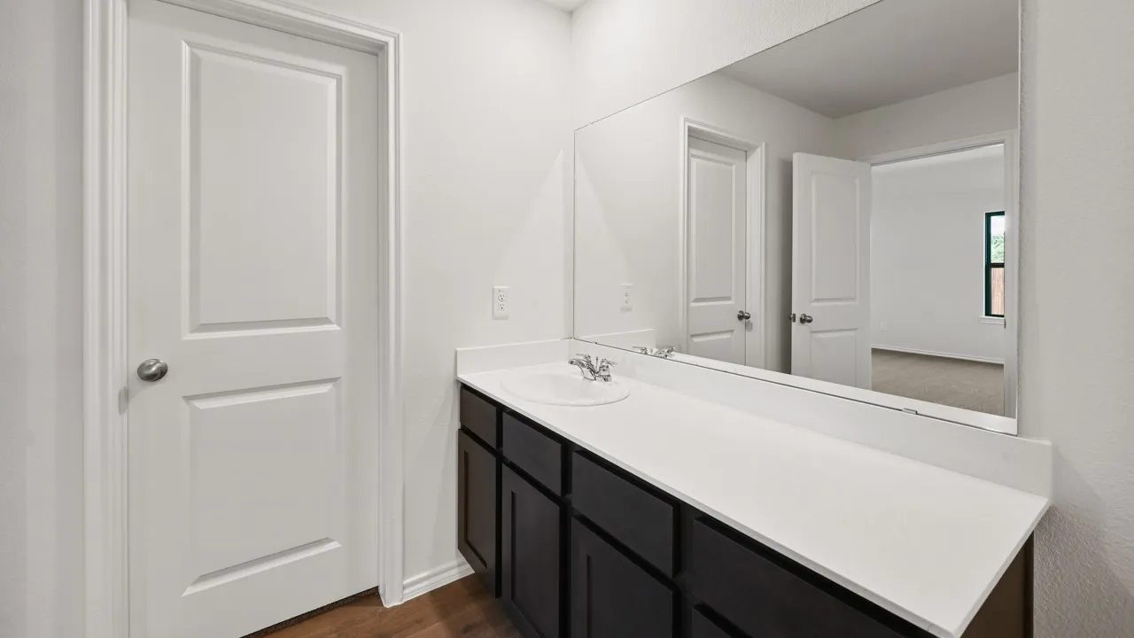 Bathroom vanity with an undermount sink, a white countertop, and dark wood-finish cabinetry