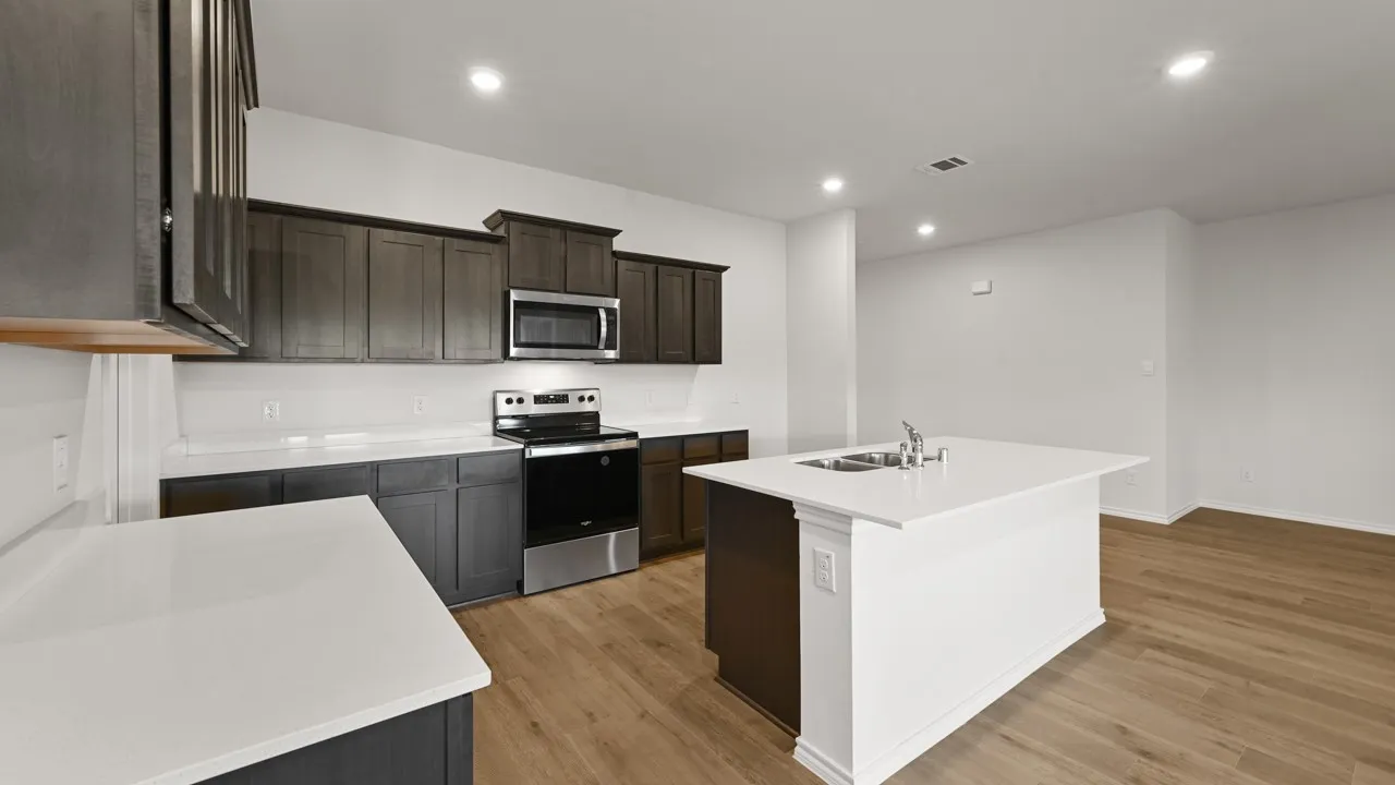 Kitchen featuring dark wood-finish cabinetry, stainless steel appliances, and white countertops