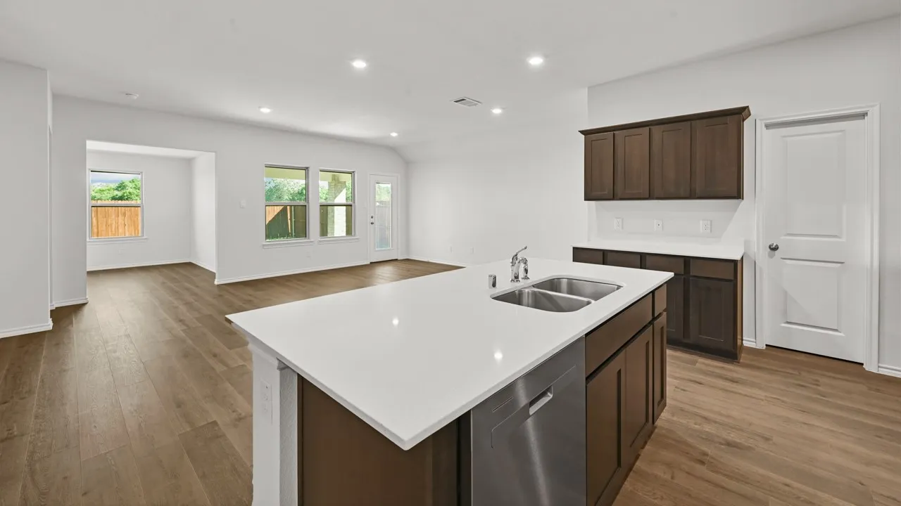 Modern kitchen island featuring a double stainless steel sink, a chrome faucet, and integrated dishwasher