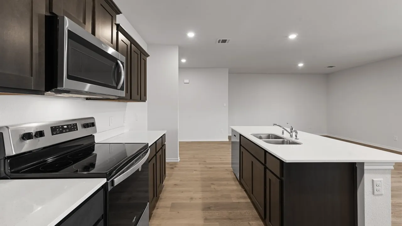 Kitchen featuring dark wood cabinetry, stainless steel appliances, white countertops, and wood-finish flooring
