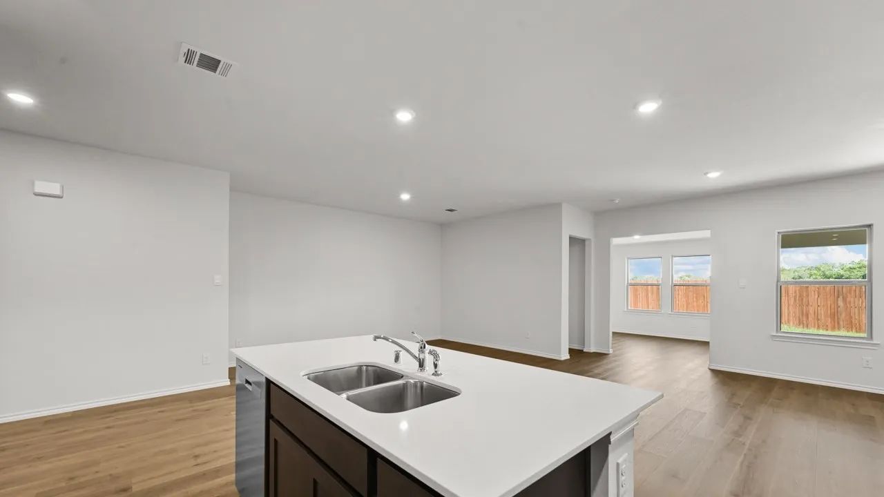 Kitchen island featuring a dual stainless steel sink, contemporary faucet, and white countertop
