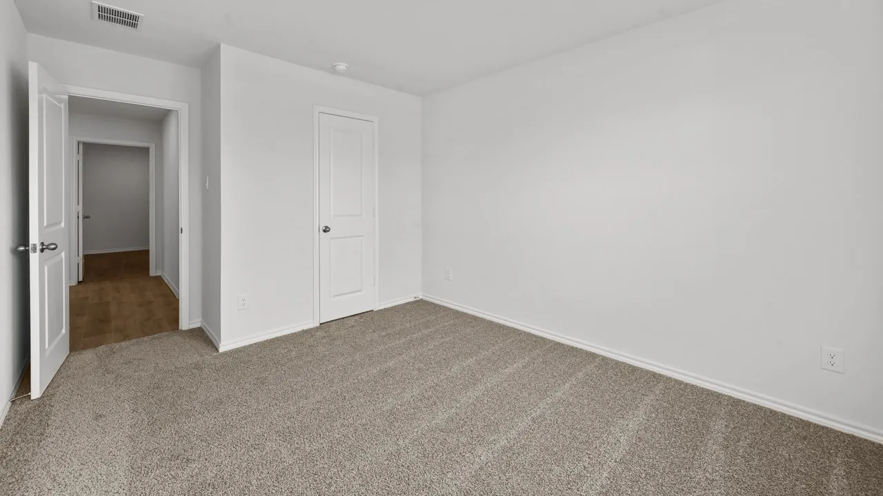 Carpeted room with white walls, baseboards, and trim