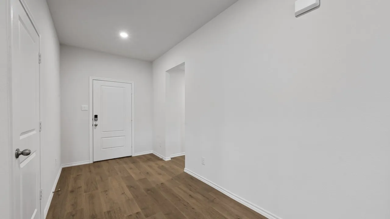 Entryway featuring wood-finish flooring, recessed lighting, and a paneled door with an electronic lock