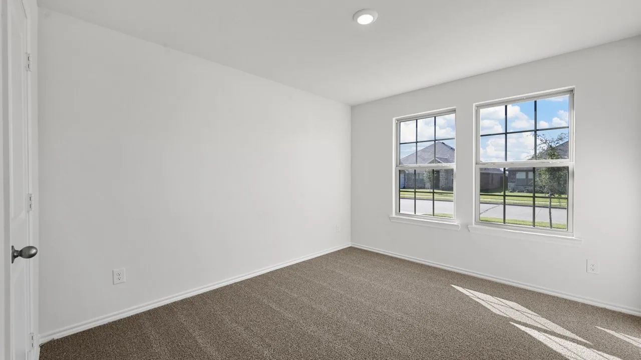 Room featuring two double-hung windows, plush carpet flooring, a white paneled door with dark hardware, and recessed ceiling lighting