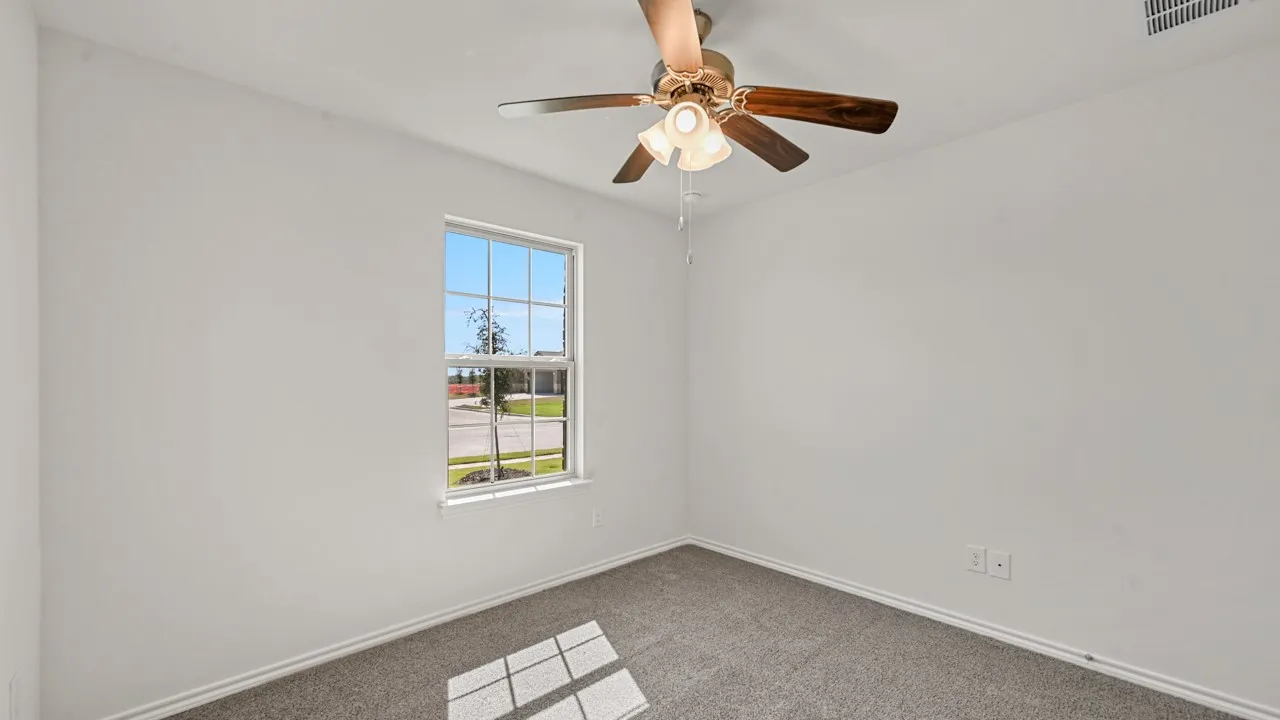 White-painted interior room featuring gray carpet flooring and a window with white trim