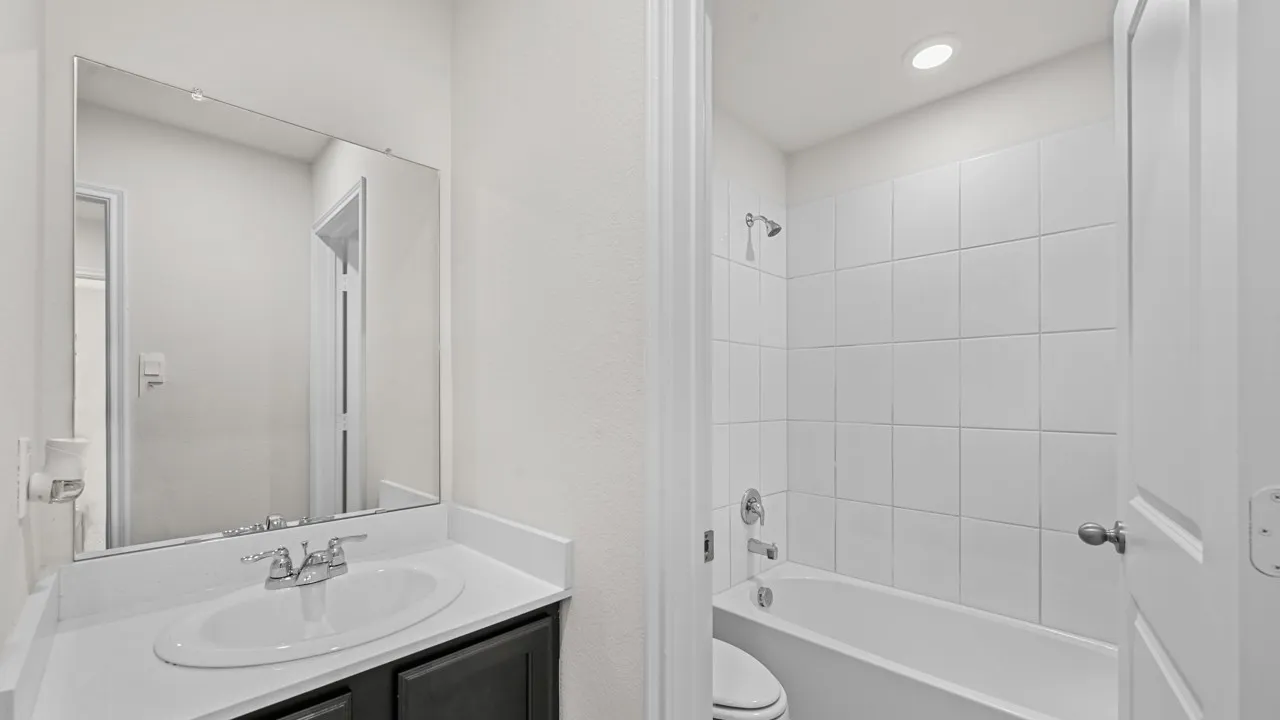 Bathroom featuring a white vanity countertop, undermount sink, and dark wood-finish cabinetry
