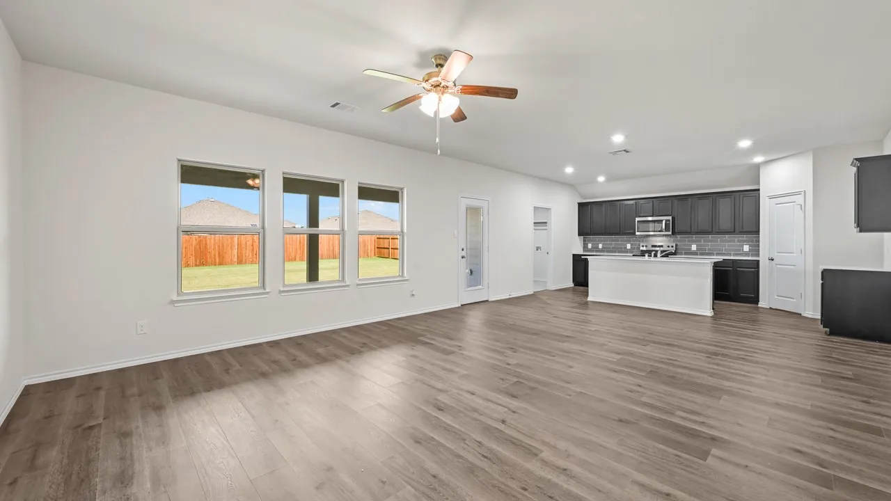 Open-concept living space featuring wood-finish flooring, recessed lighting, and a ceiling fan