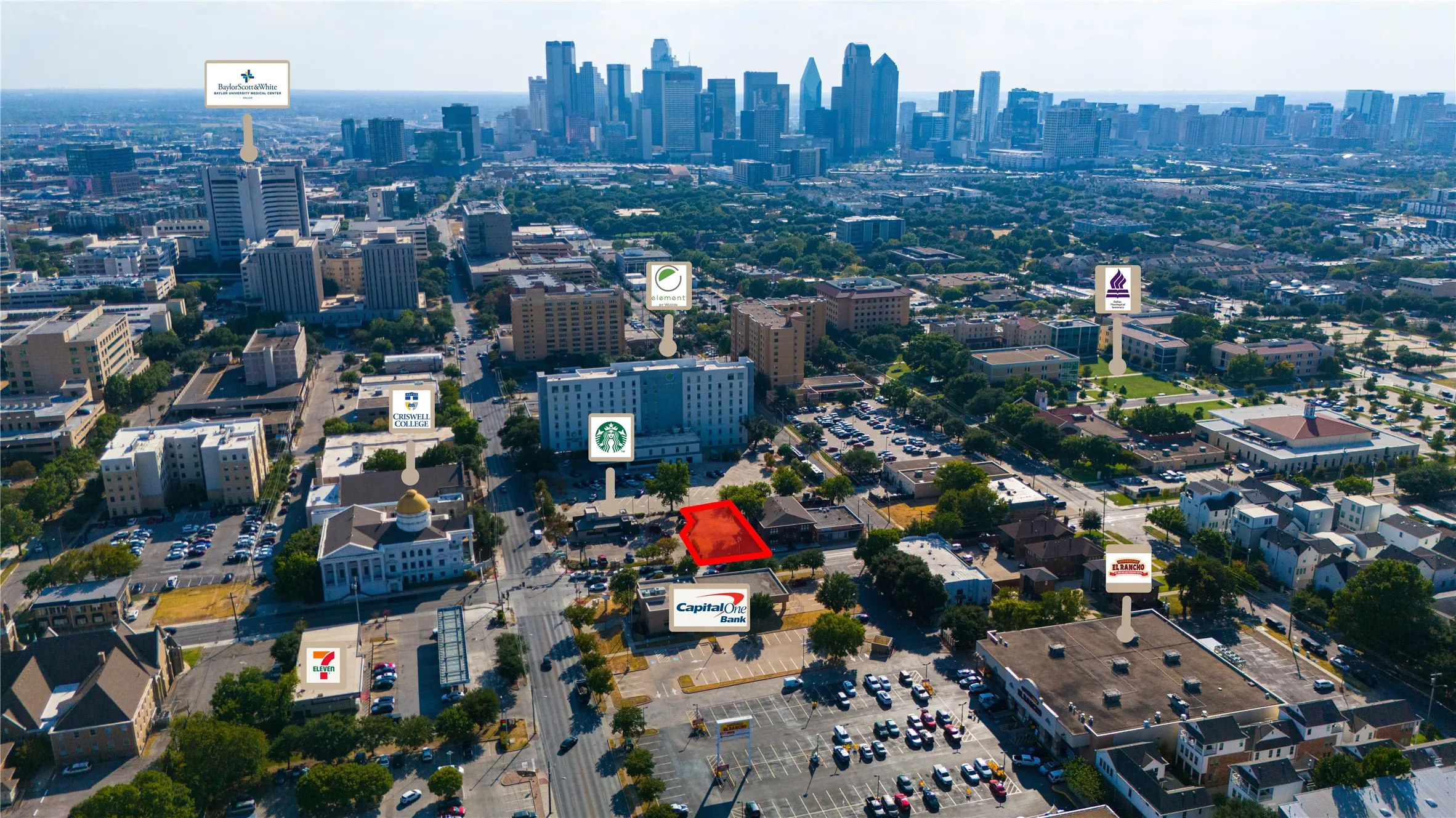 Urban setting with a prominent city skyline, multiple commercial buildings, and surface parking areas
