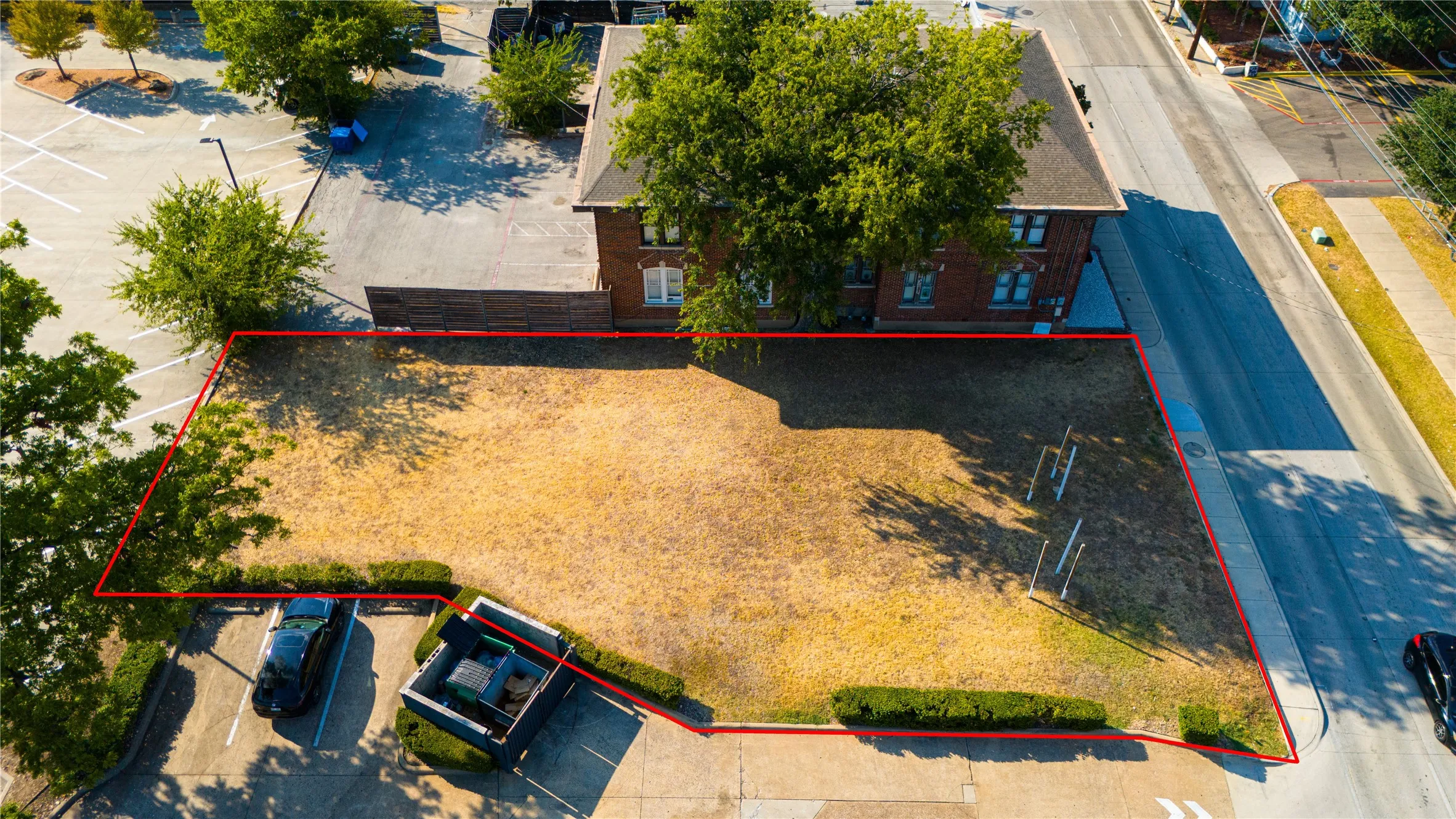 Expansive lot featuring mature perimeter shrubbery and a clear, level ground surface