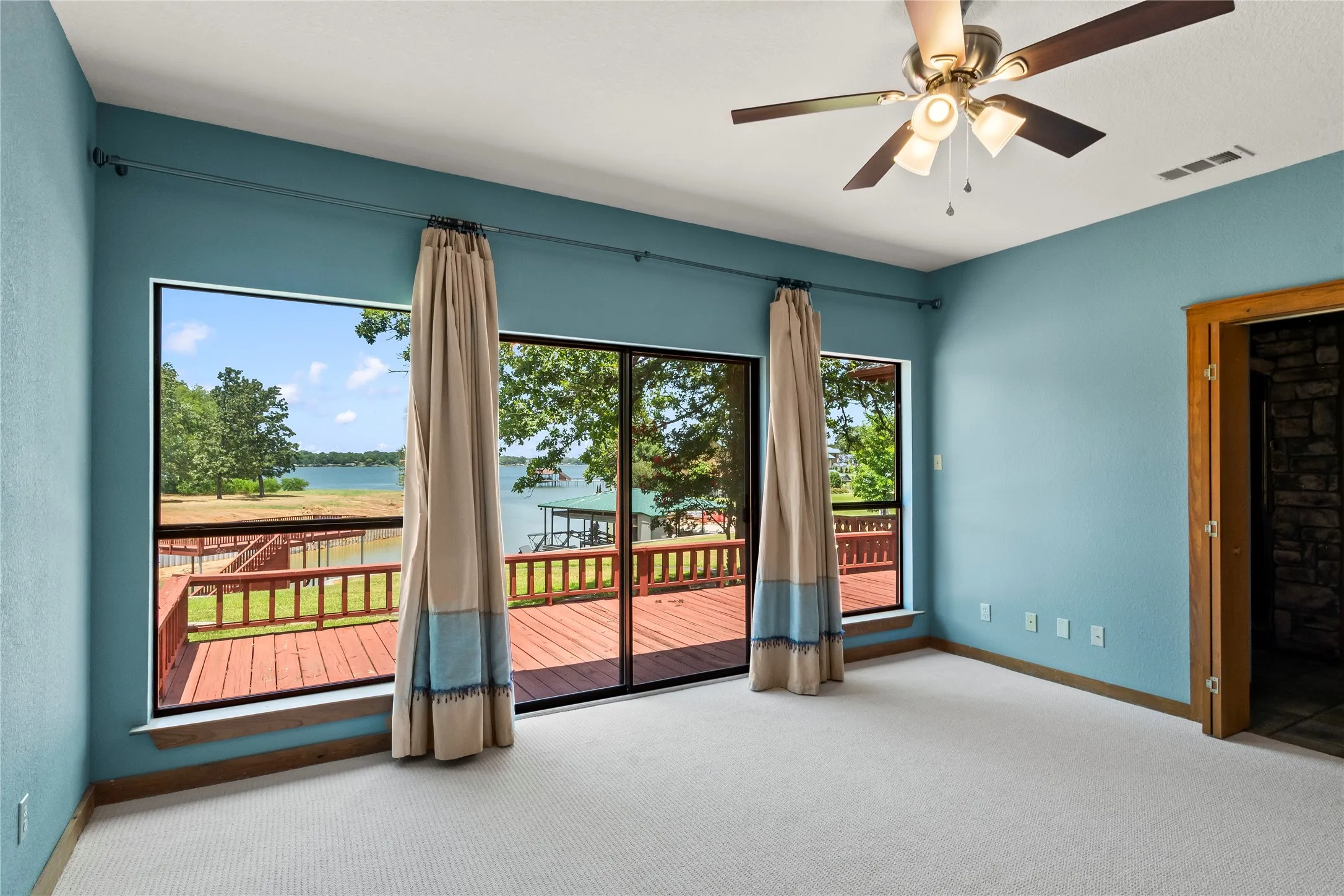 Waterside Primary Suite with doors to the back deck and lovely views.