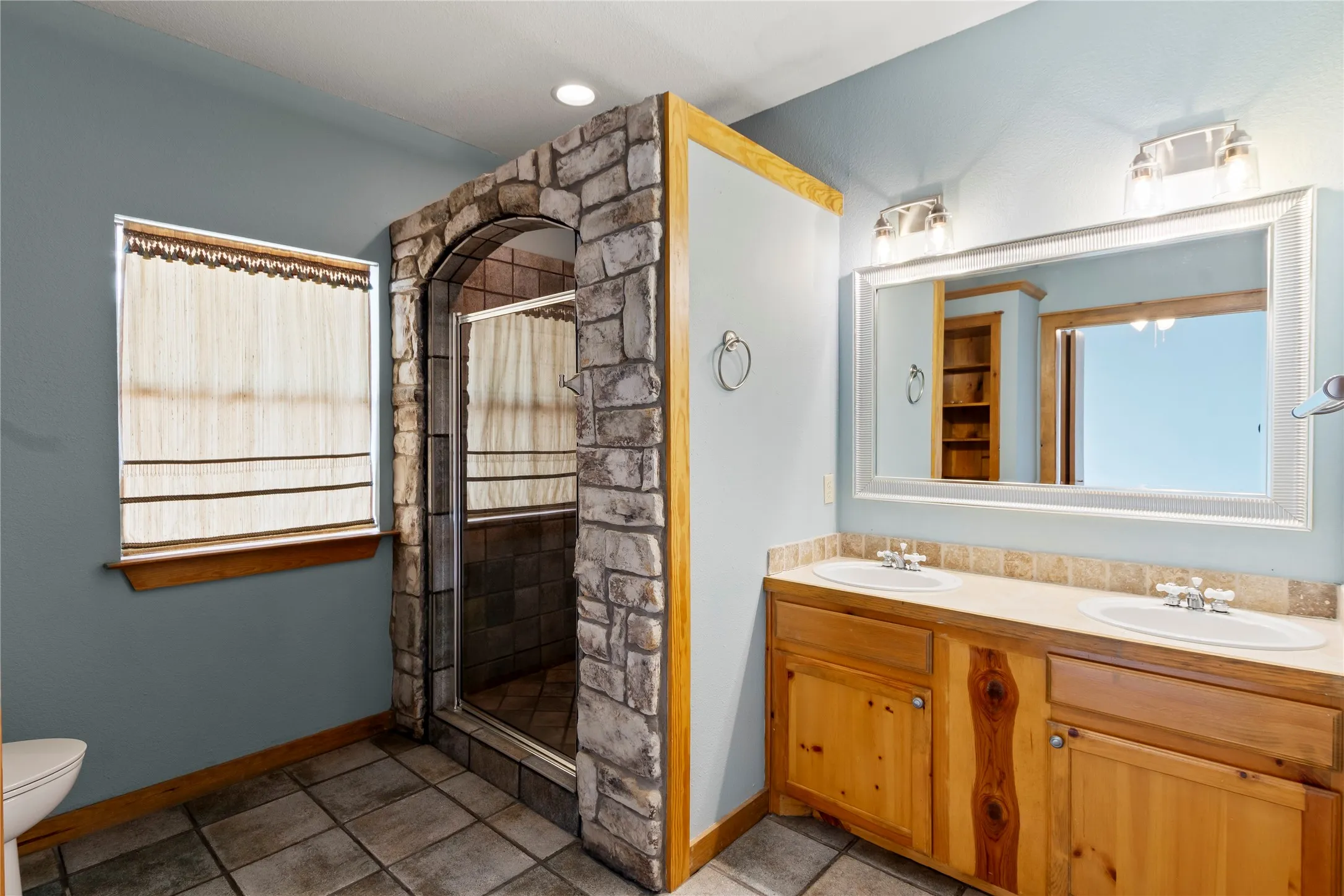 Spacious primary suite with walk in shower and double sink vanity.