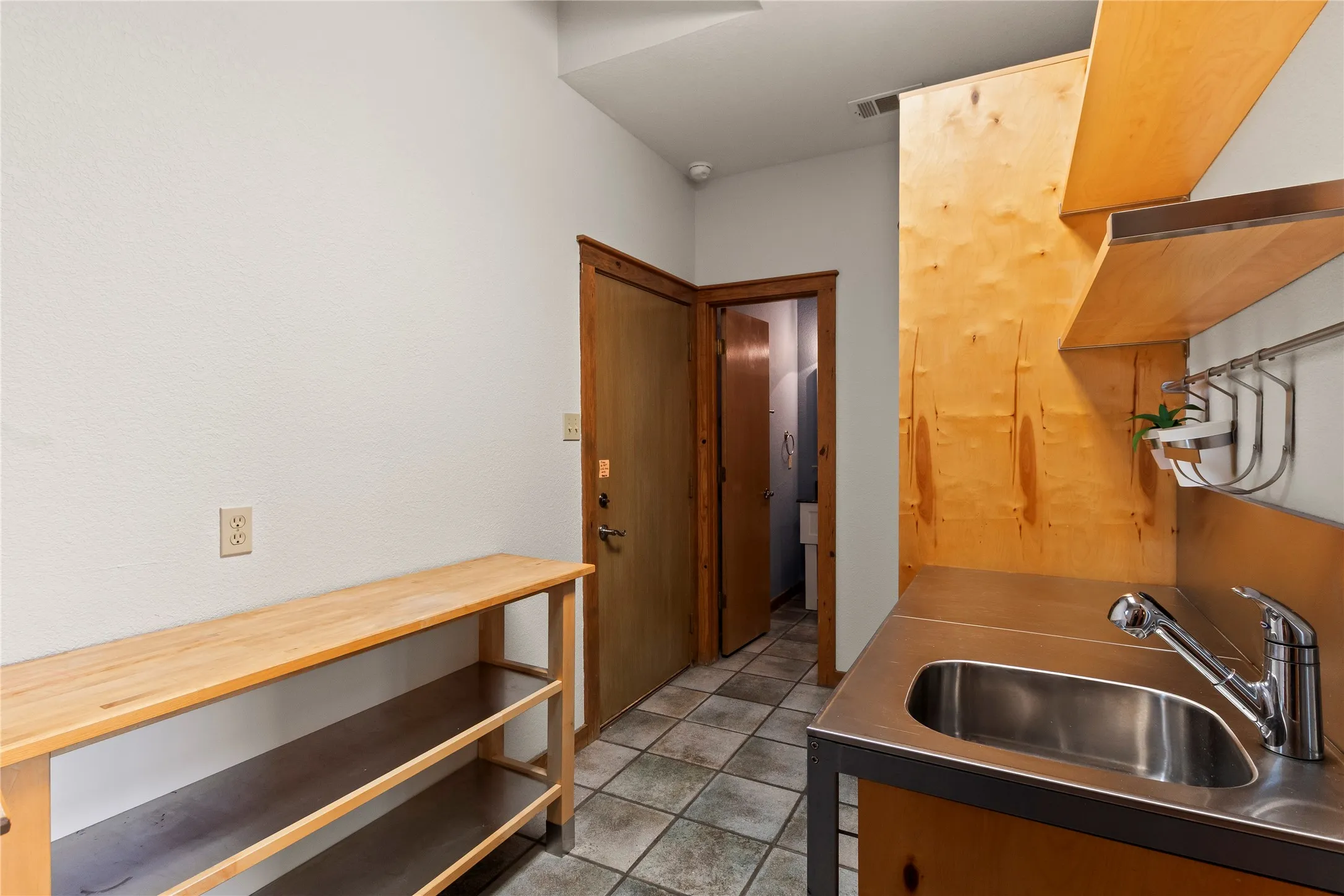 Spacious laundry room with sink with access door from exterior of the home, garage, and just off the kitchen.