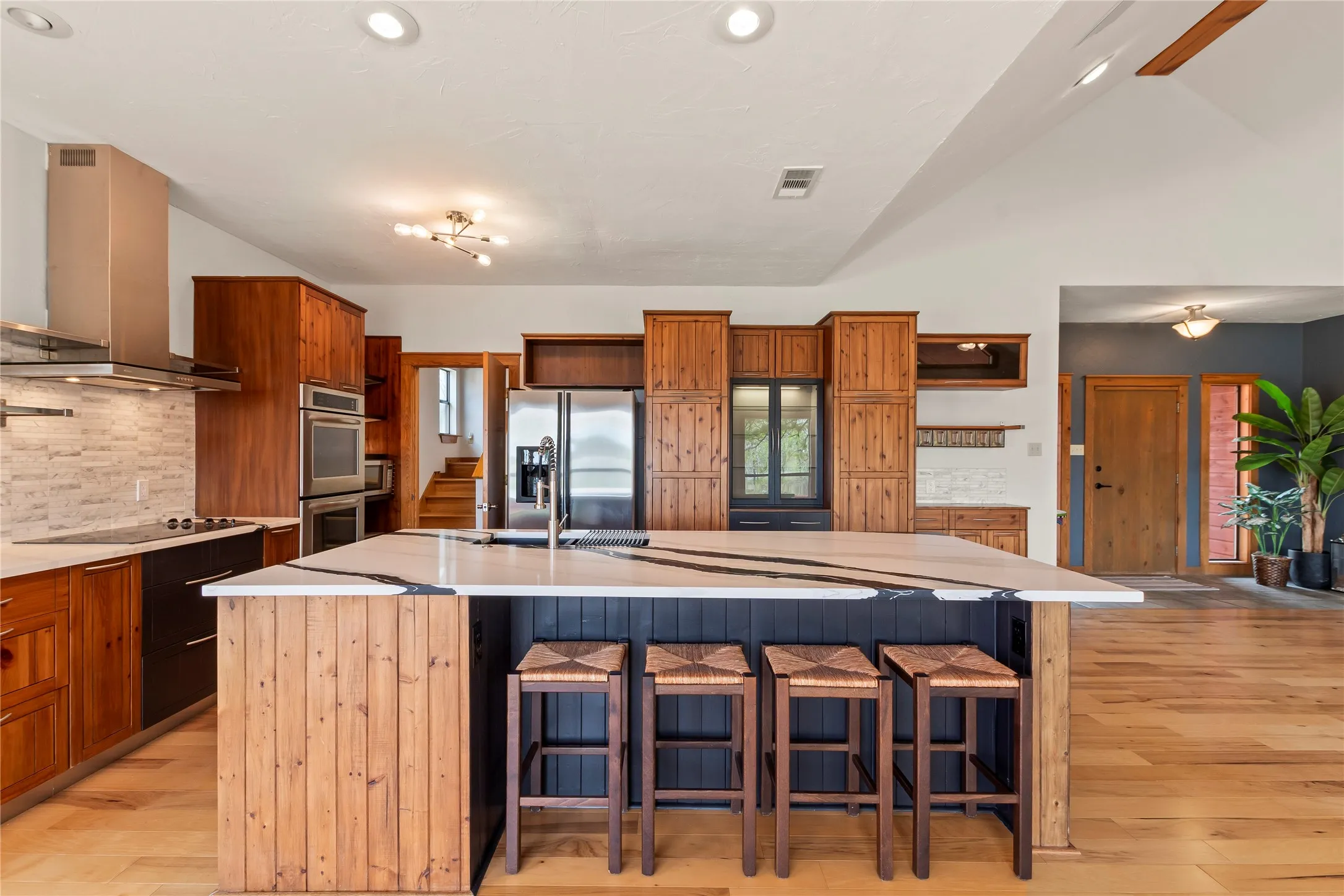 Stainless steel appliances including double ovens and vent hood. Bar seating perfect for entertaining.