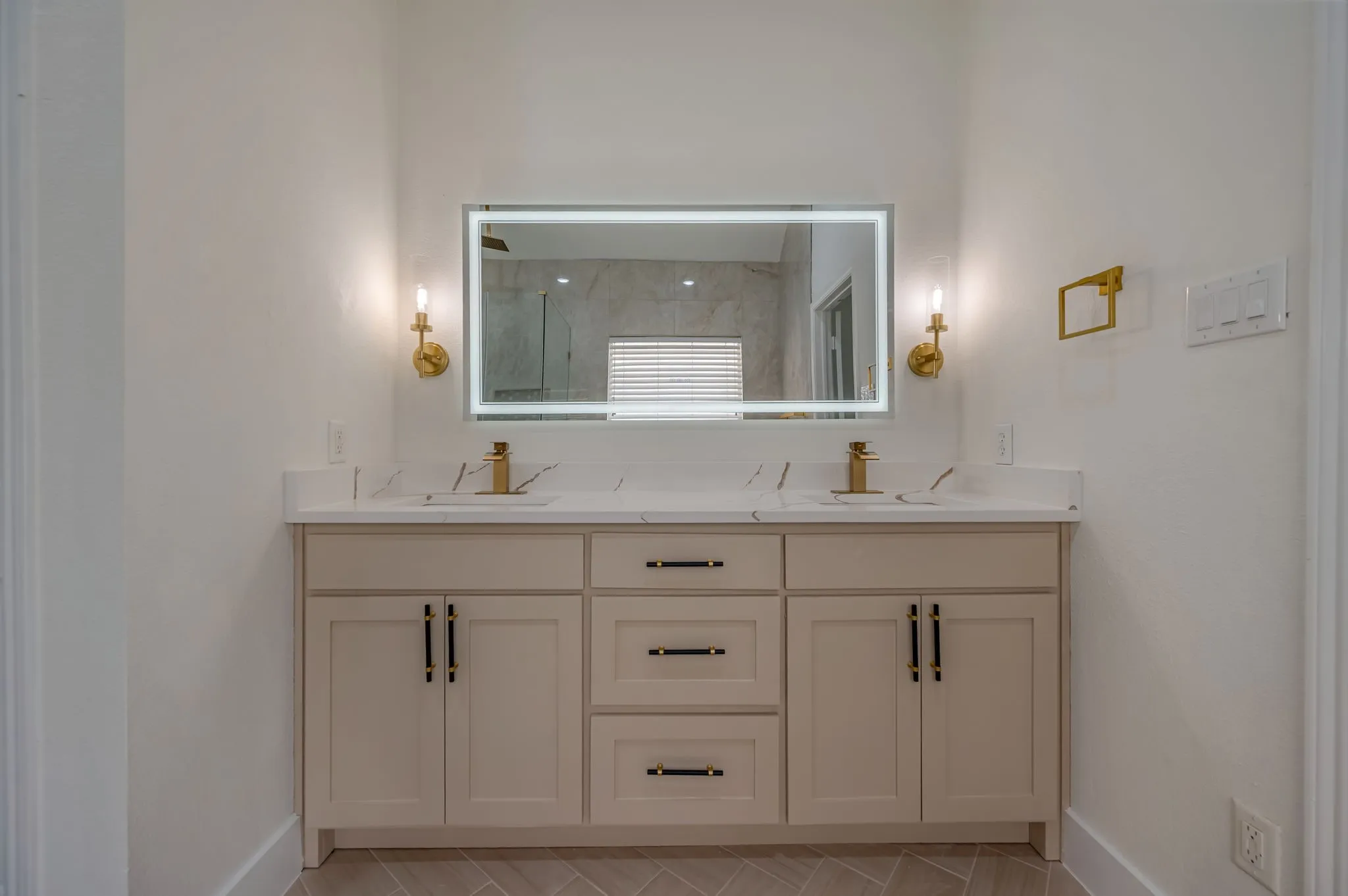 Dual vanity with integrated sinks, quartz countertops, and gold-finish fixtures