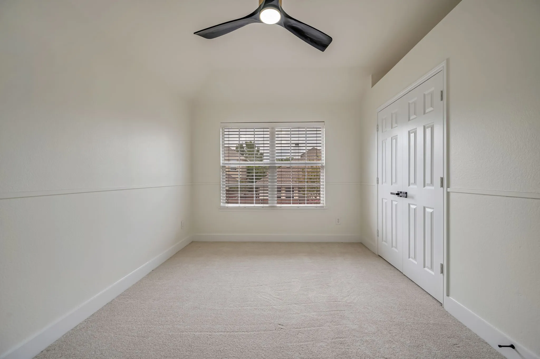 Neutral tone carpet with window blinds, a modern ceiling fan, and a paneled closet door