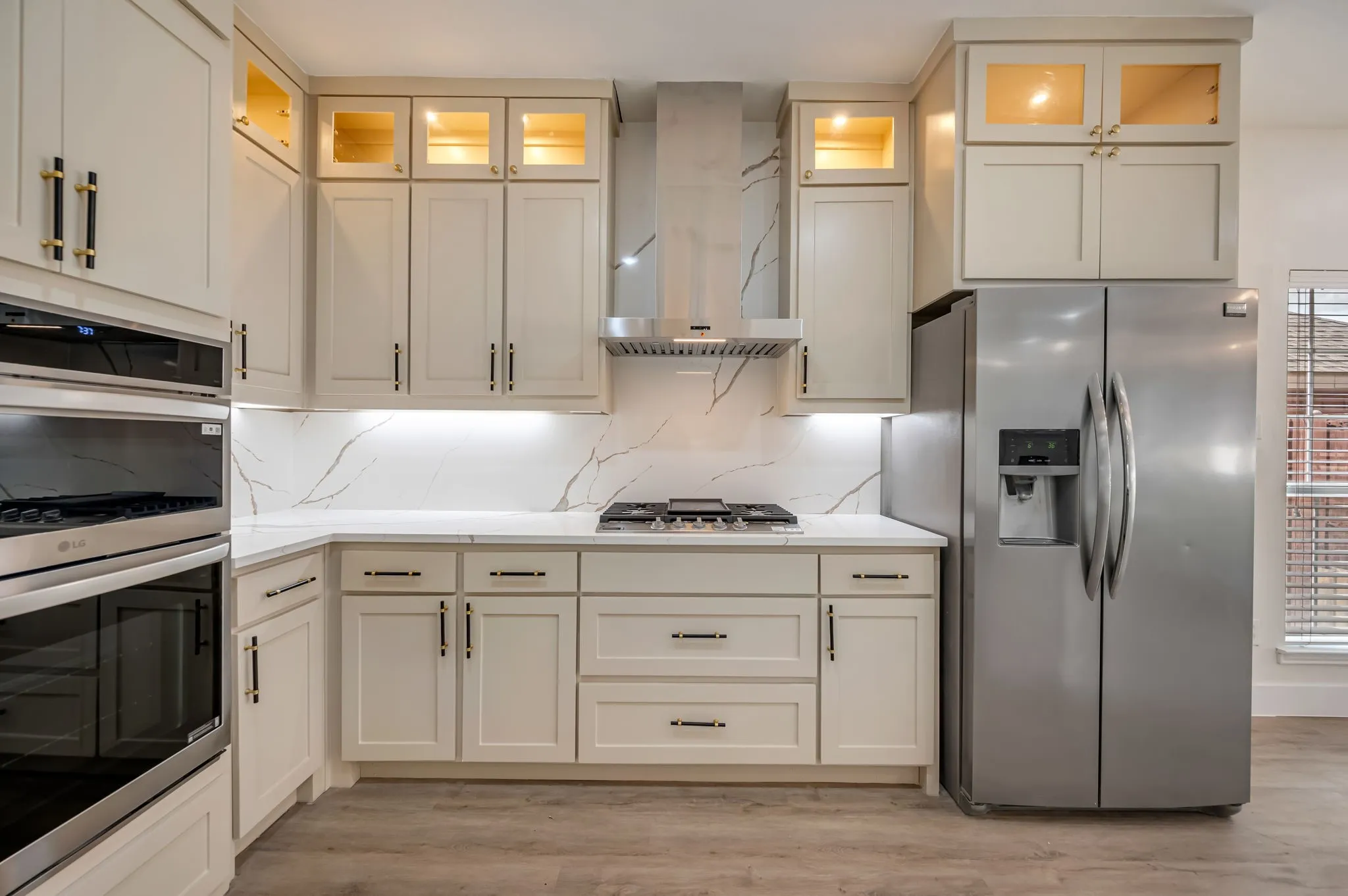 Kitchen featuring brand new shaker cabinetry, stainless steel appliances, white countertops, and a full-height quartz backsplash