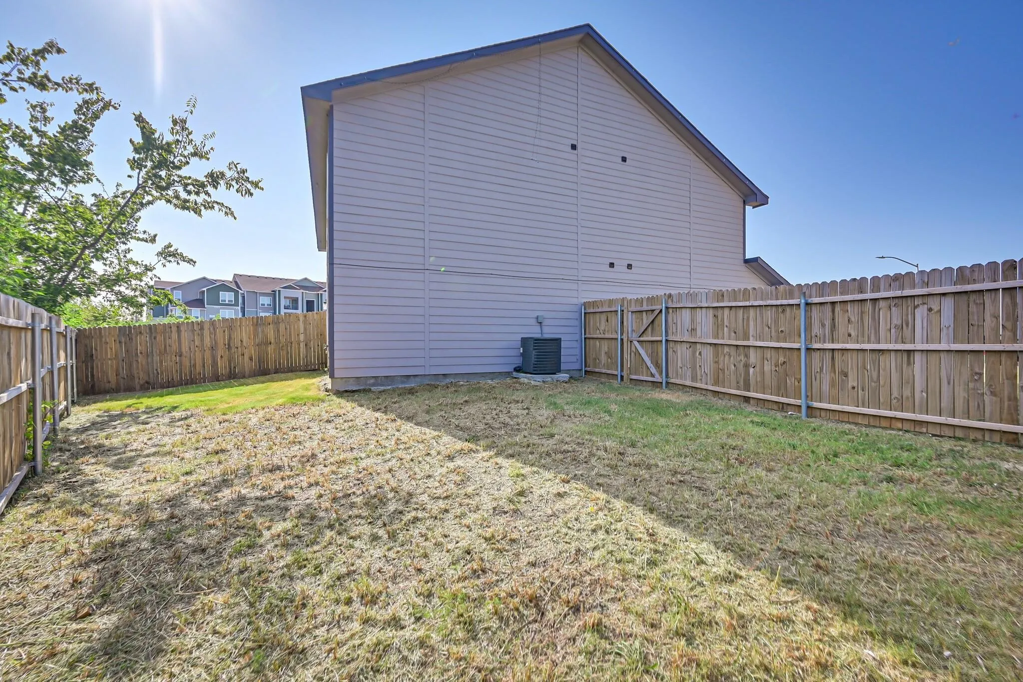 Back of house with a fenced backyard