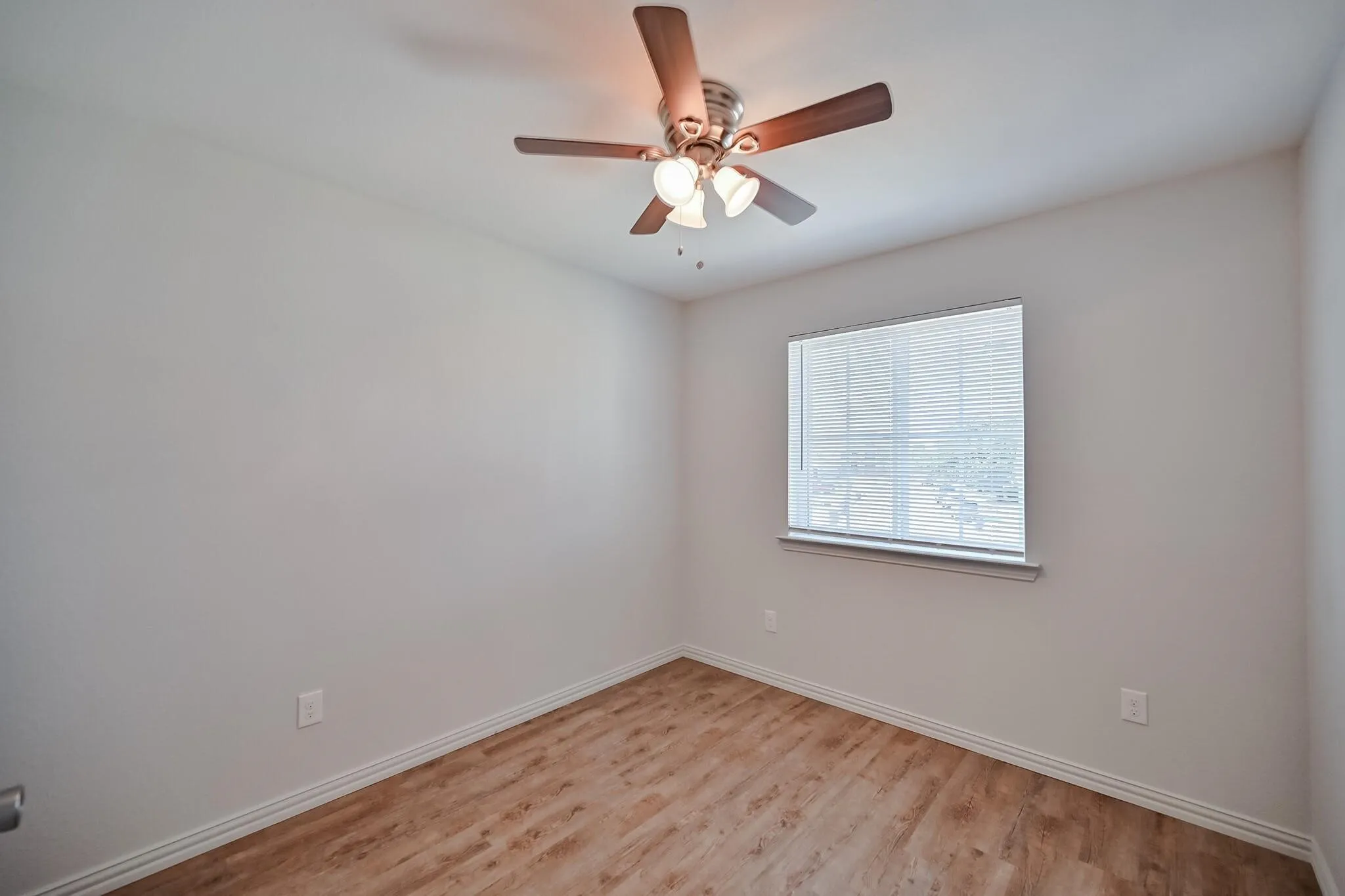 Spare room featuring light wood finished floors and ceiling fan