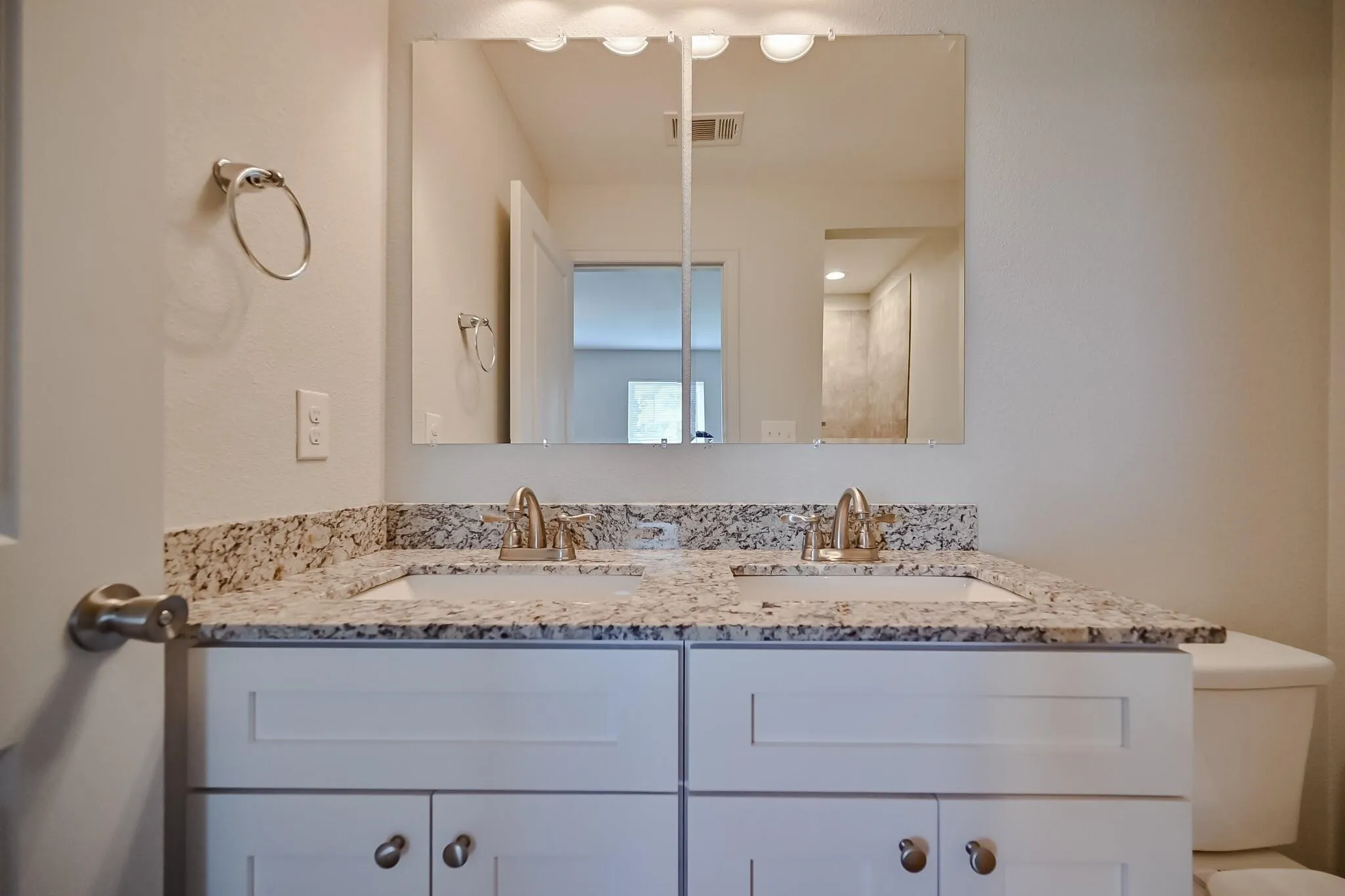 Full bath with double vanity and toilet