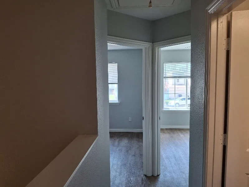 Corridor featuring wood finished floors and baseboards