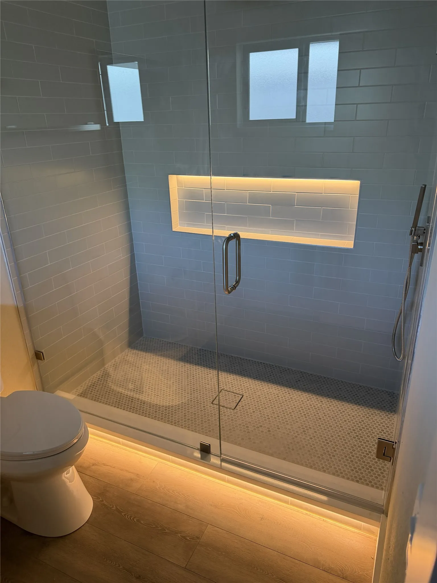 Frameless glass shower enclosure in 2nd primary 2nd primary with a recessed niche, subway tile walls, and a tiled shower pan