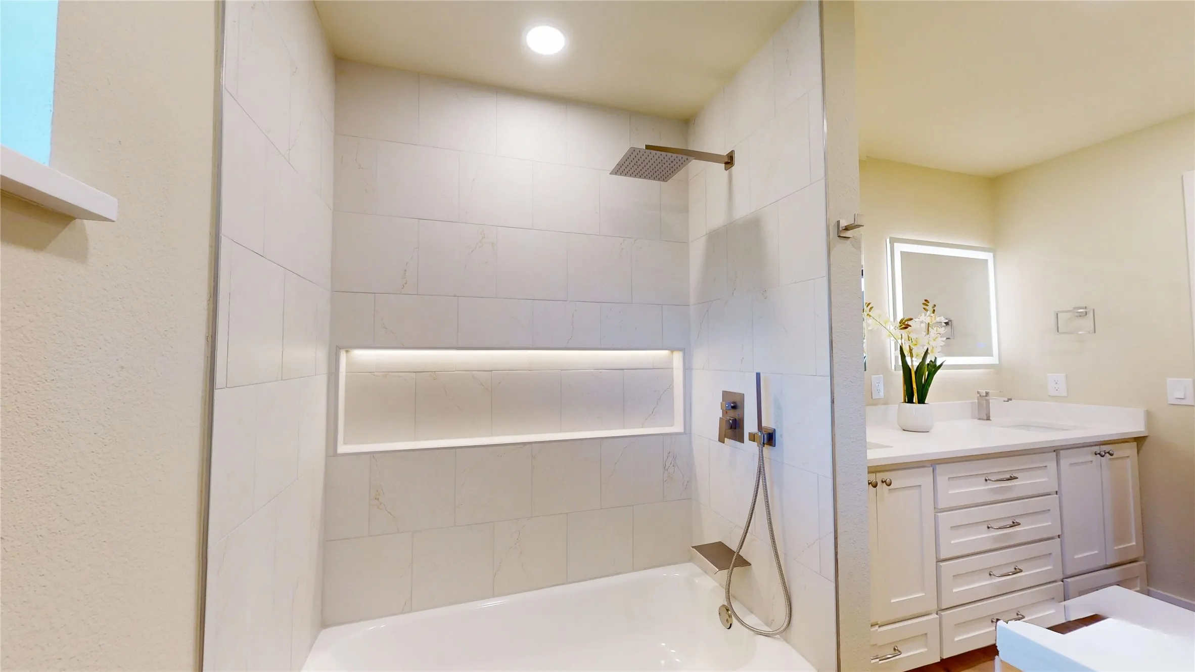 Tiled tub/shower combination with a recessed niche and integrated lighting