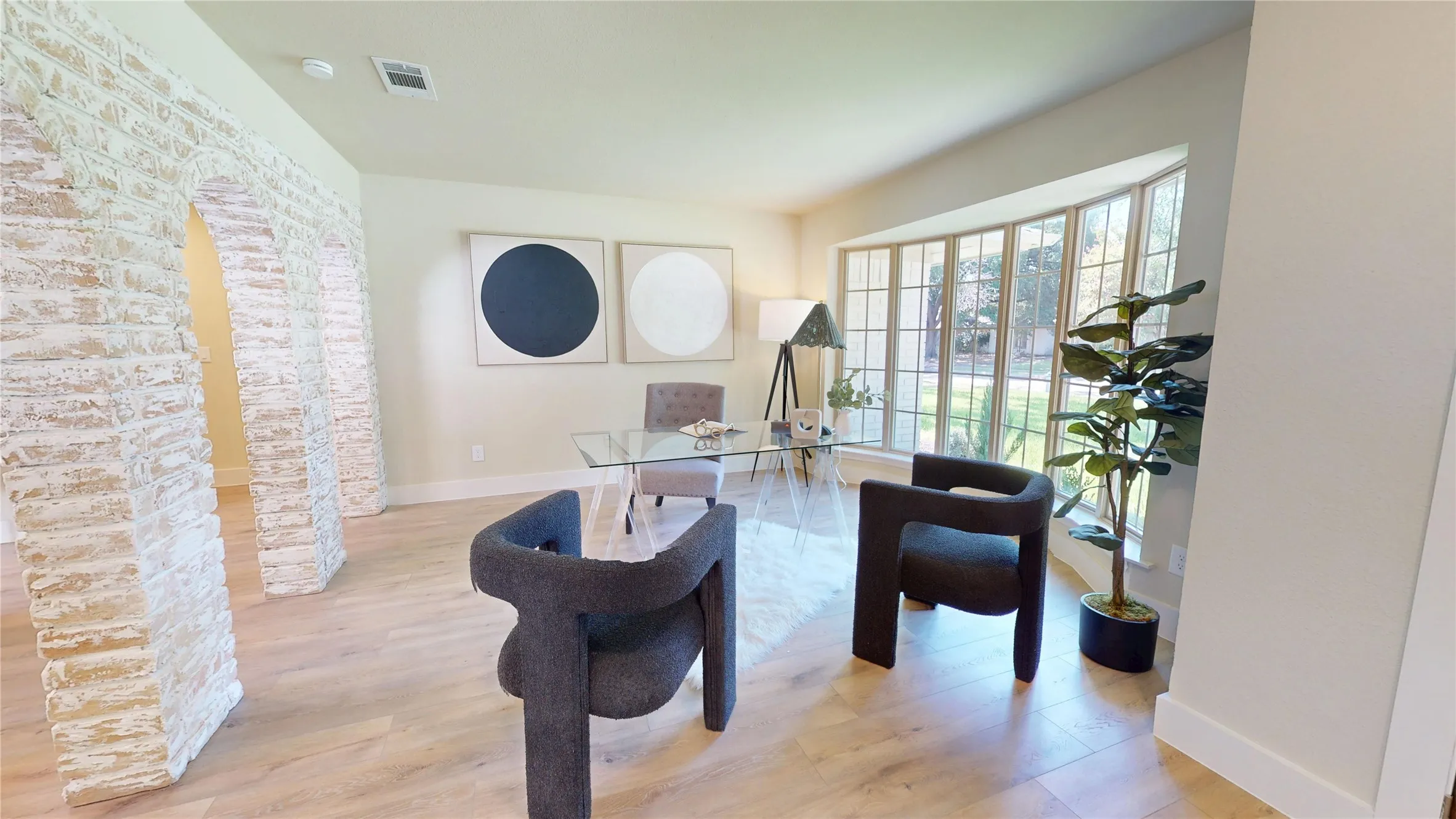 Wood-finish flooring, a bay window with multiple panes, and archway structural details