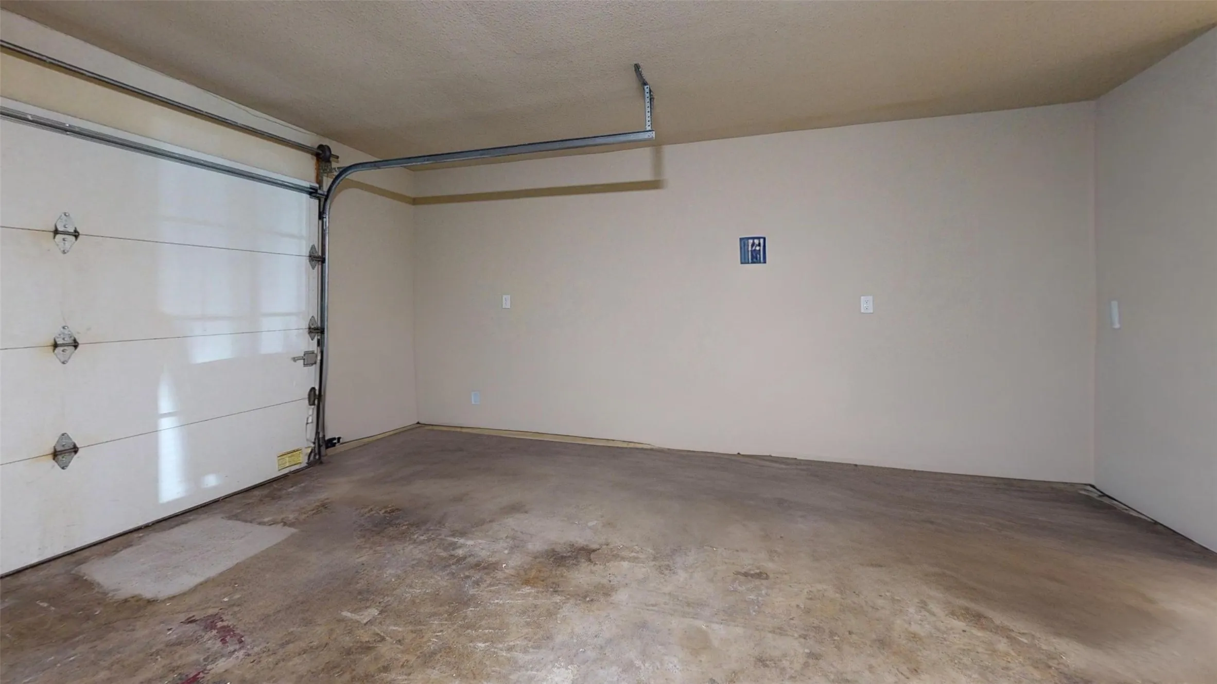 Attached garage with a sectional overhead door and painted walls