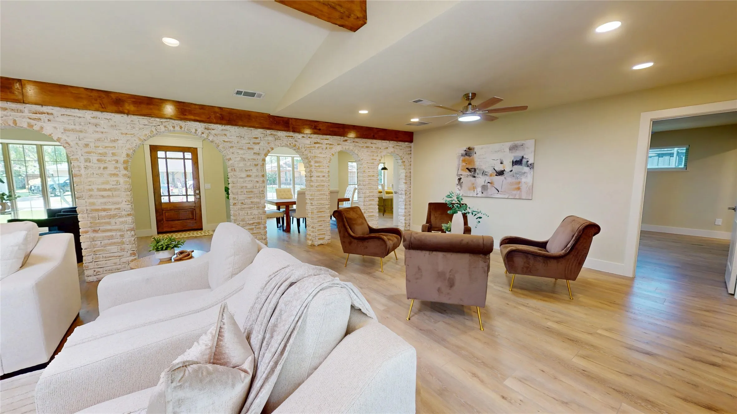 Vaulted ceiling with exposed wood beams, recessed lighting, wood-finish flooring, and arched German Schmear brick wall details