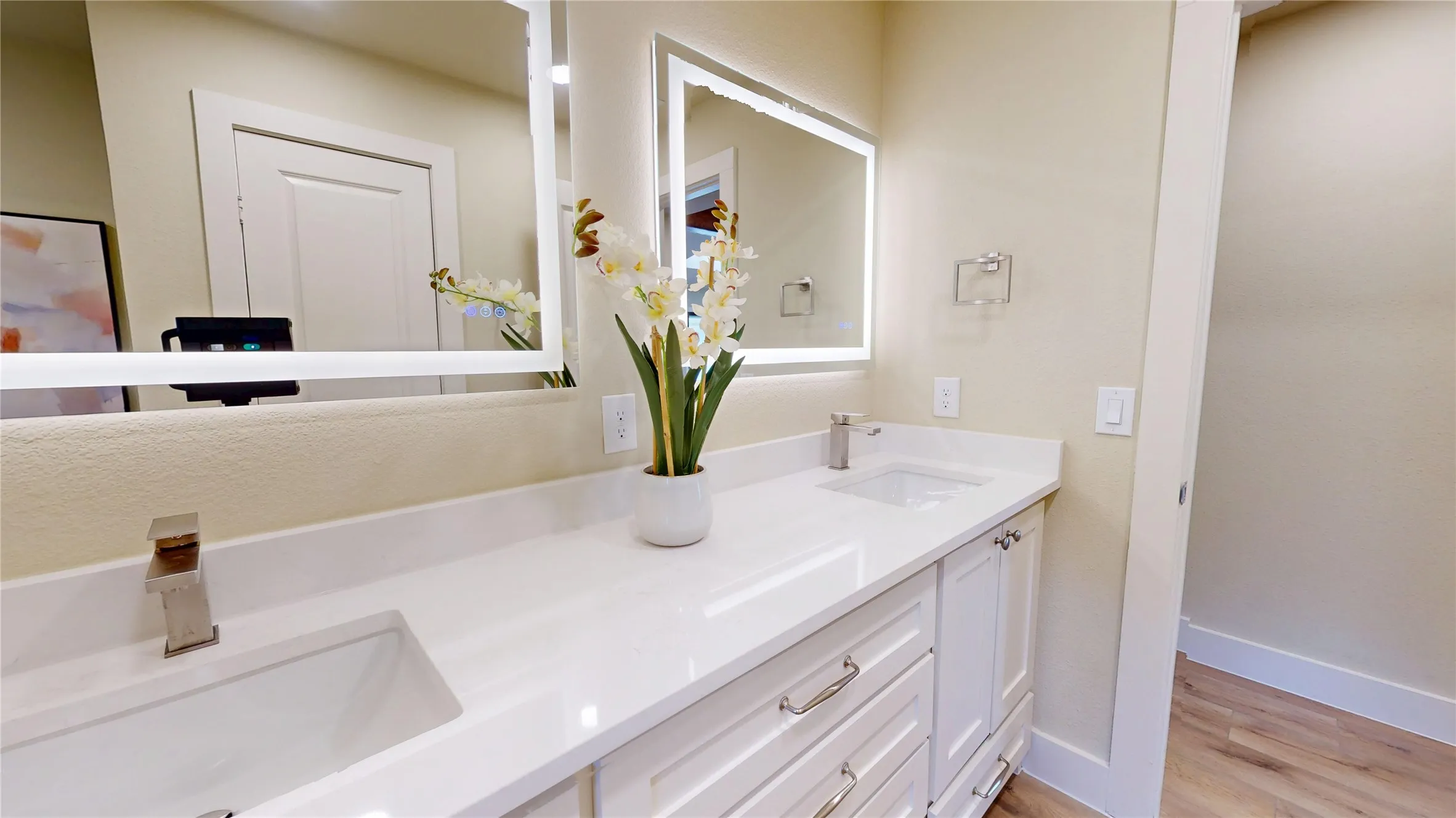 Dual vanity with integrated rectangular sinks, white countertops, and white wood-finish cabinetry