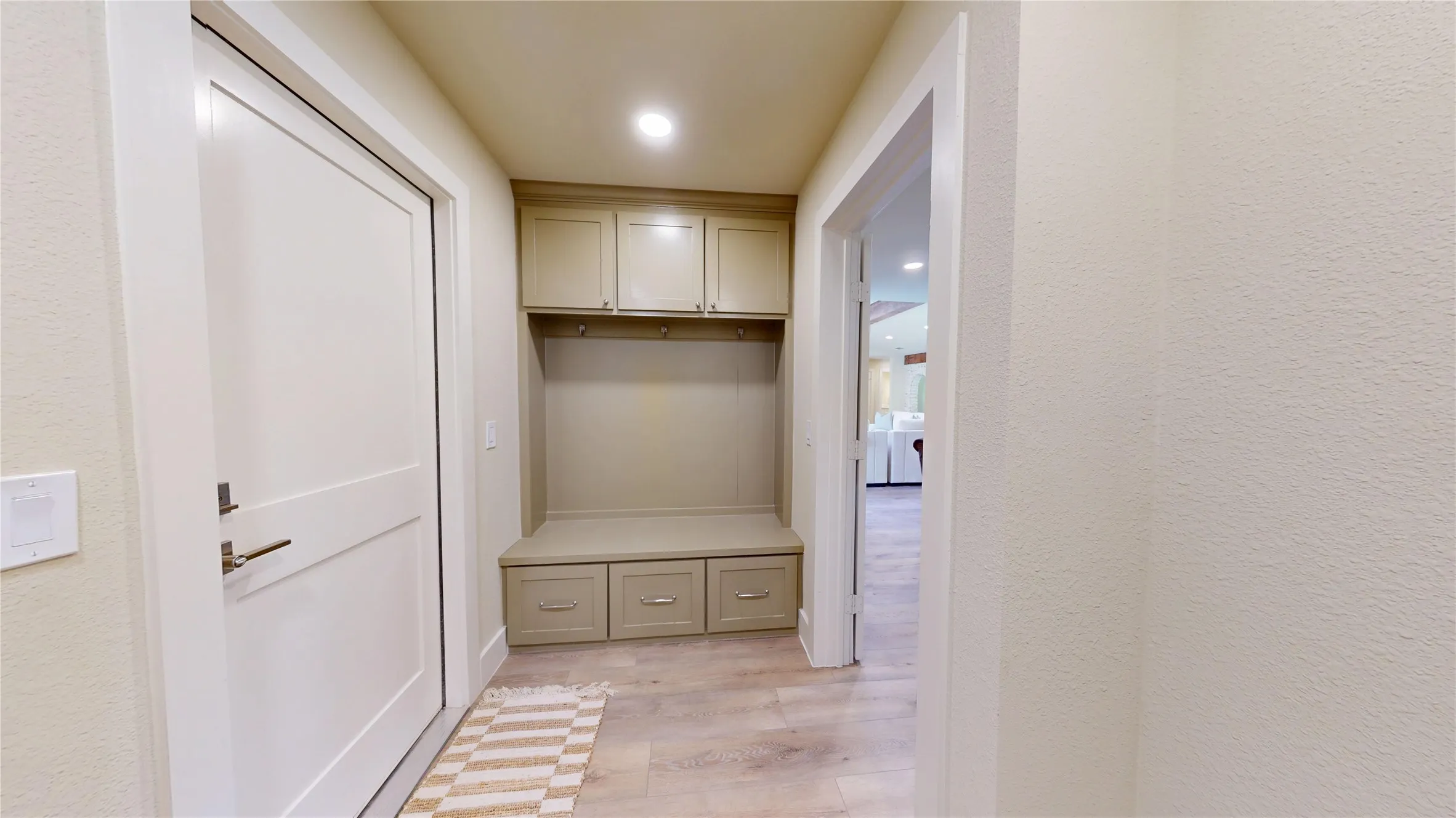 Built-in hall tree with upper cabinetry and lower drawers, recessed lighting, and wood-finish flooring