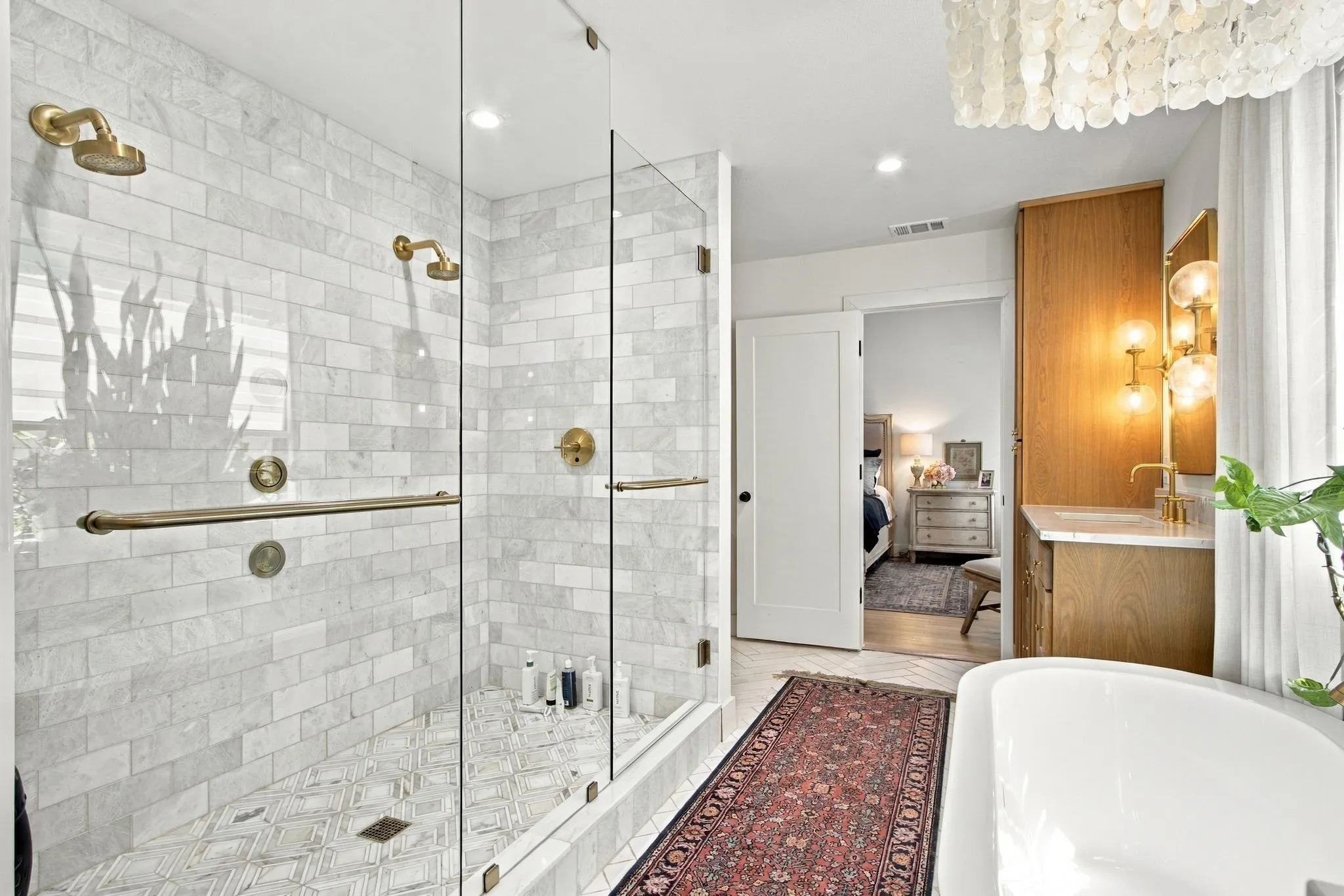 Glass-enclosed shower with subway tile surround and brass fixtures