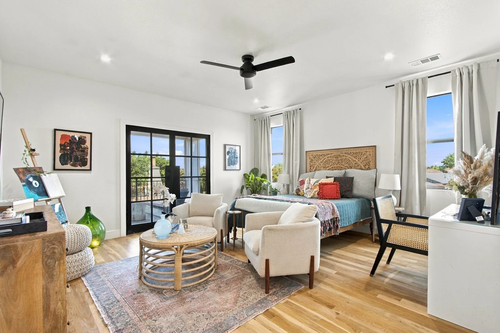 Wood-finish flooring, recessed lighting, and a black ceiling fan illuminate this bright space