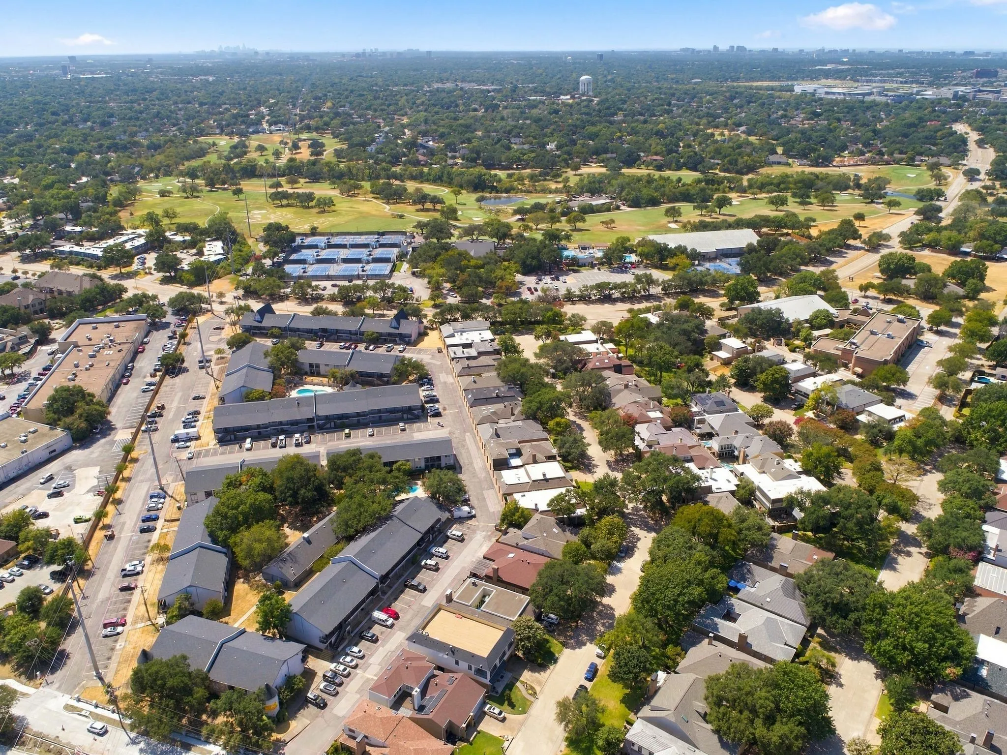 Aerial perspective featuring a residential area with varied rooflines and extensive tree canopy