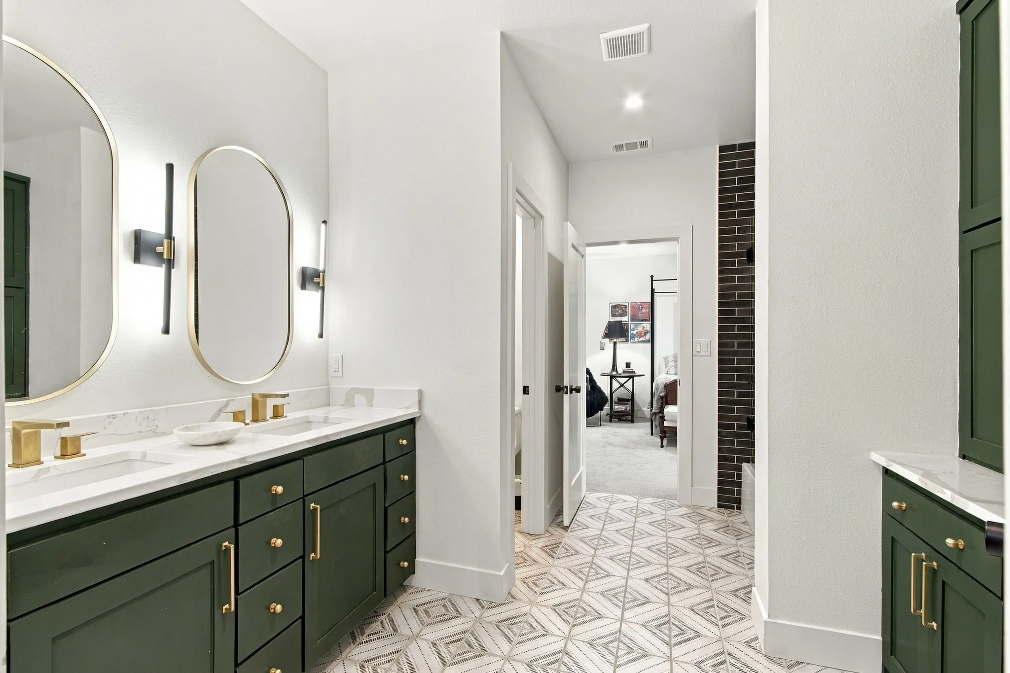 Dual vanity with green cabinetry and gold-tone hardware
