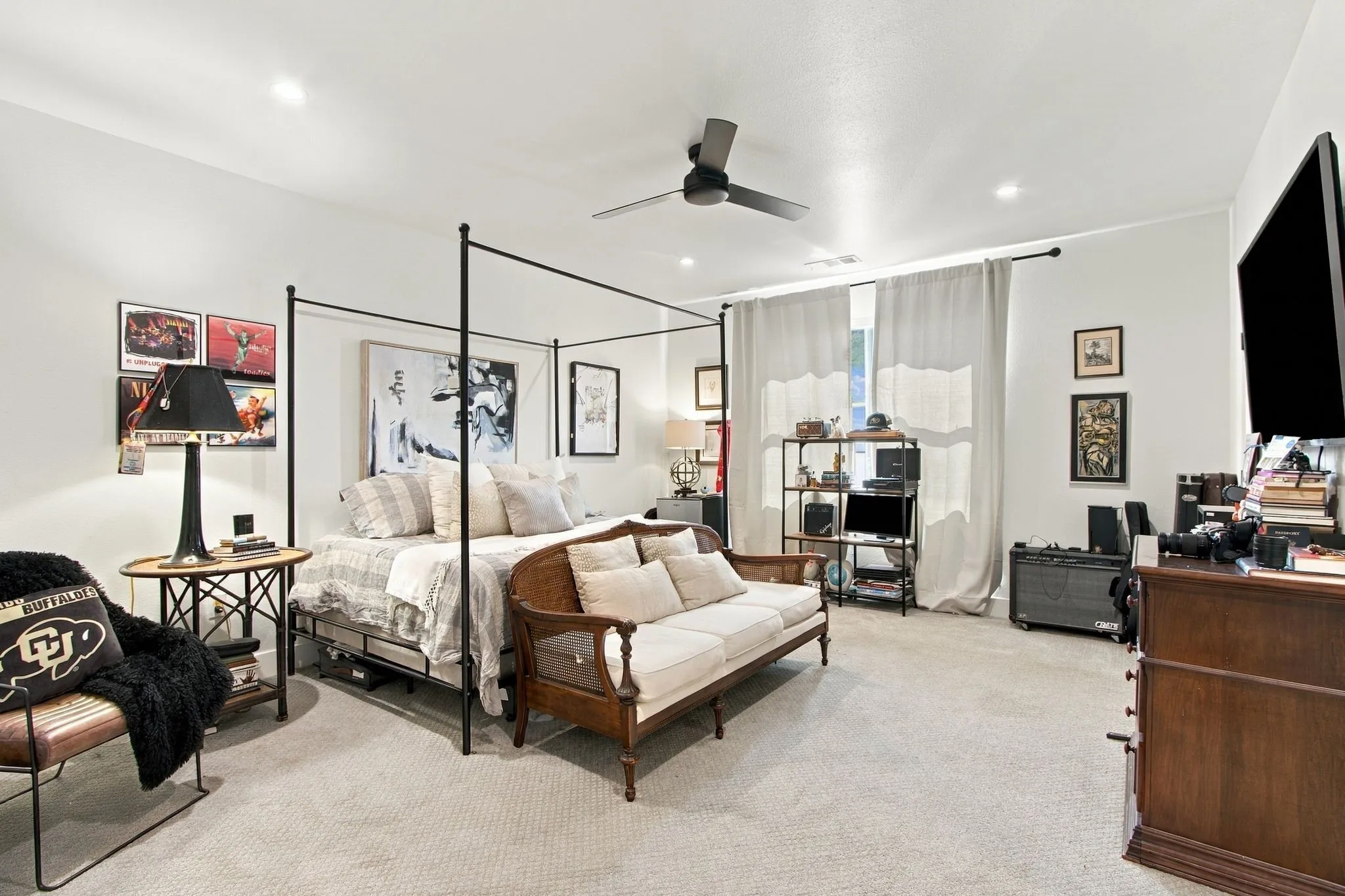 Recessed lighting, ceiling fan, carpeting, and window with light-filtering drapery