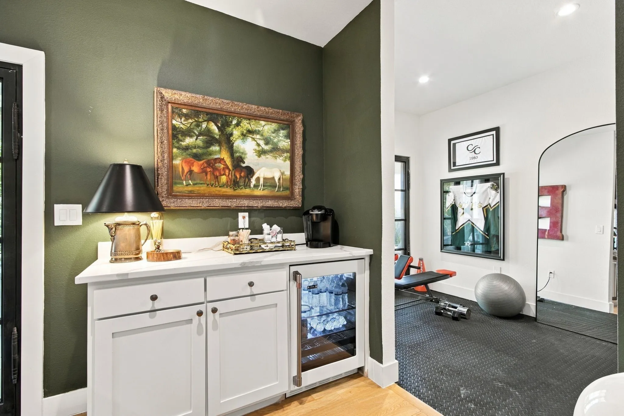 Built-in cabinetry with a beverage refrigerator, light-toned countertops, and wood-finish flooring
